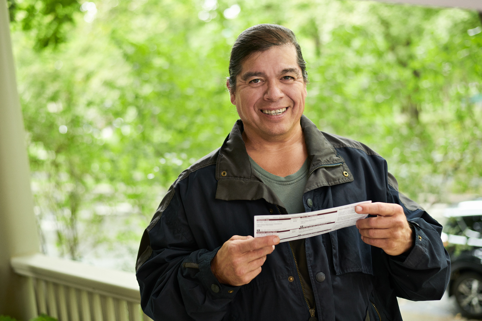 an aboriginal male man looks up at the mere on his porch