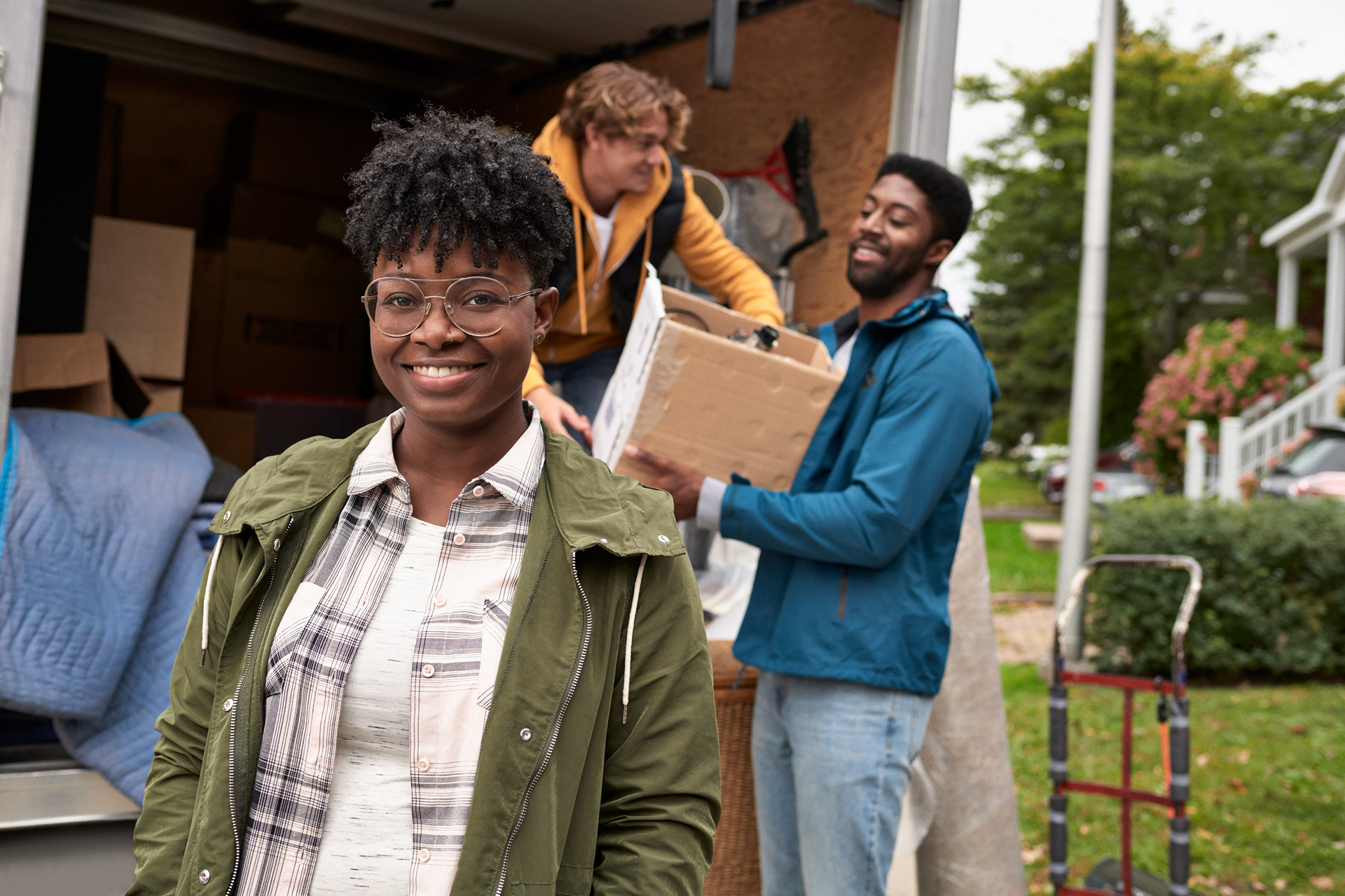 portrait of a girl that is getting help to move her personal items from a truck