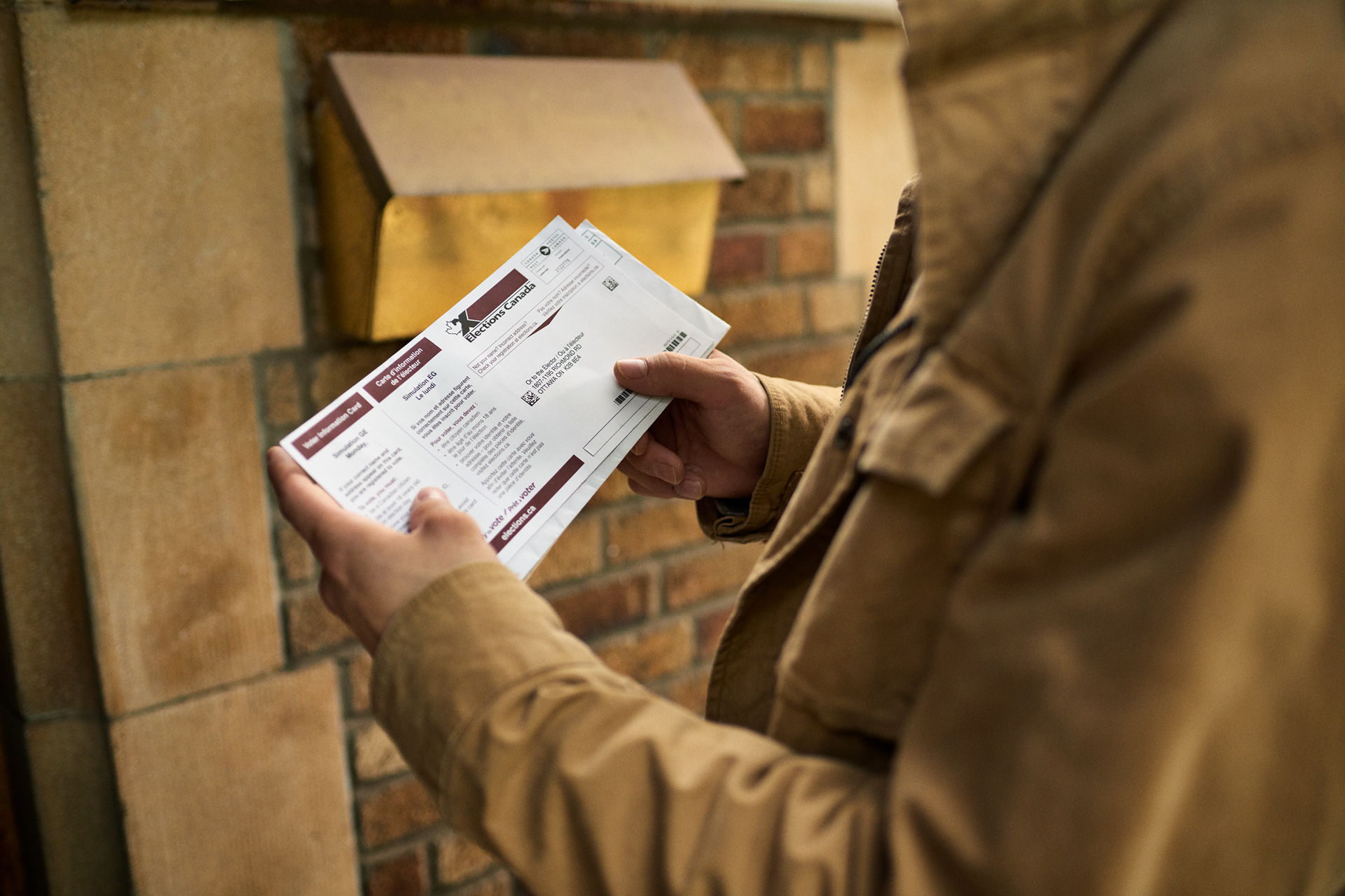 male hands holding an envelope as he looks over his elections canada voter information card