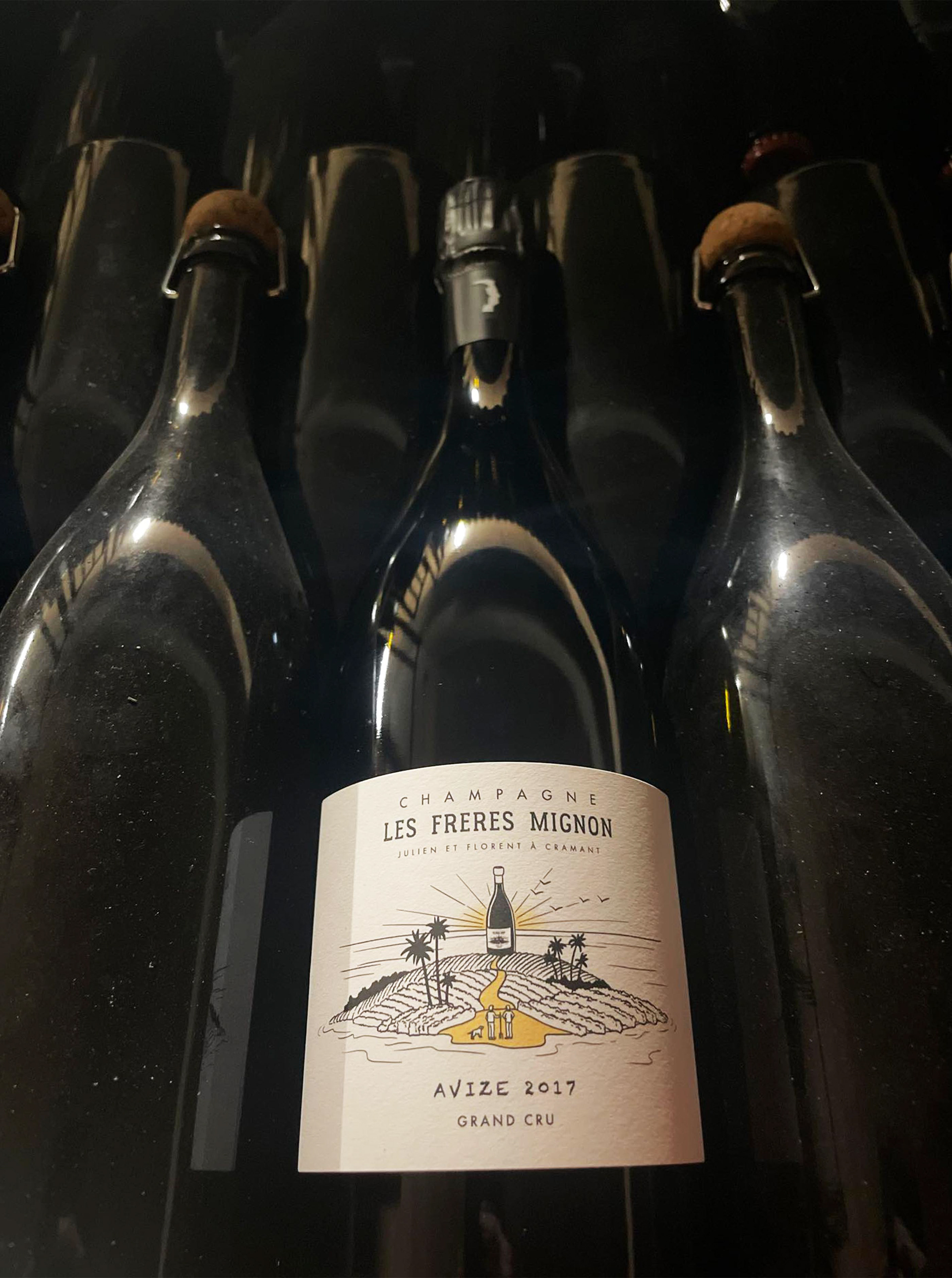 Bouteille de champagne avec une étiquette illustrée parmi d'autres bouteilles nues