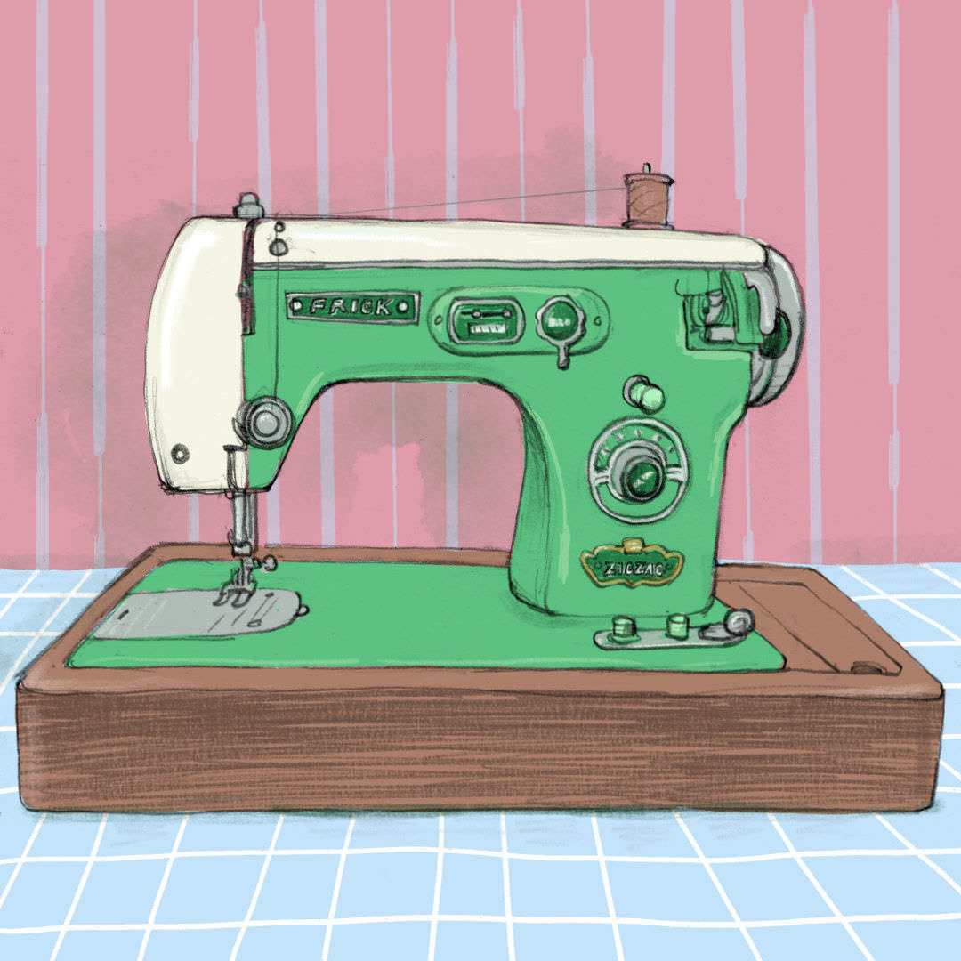 A green vintage sewing machine on a blue tablecoth in front of a pink wall