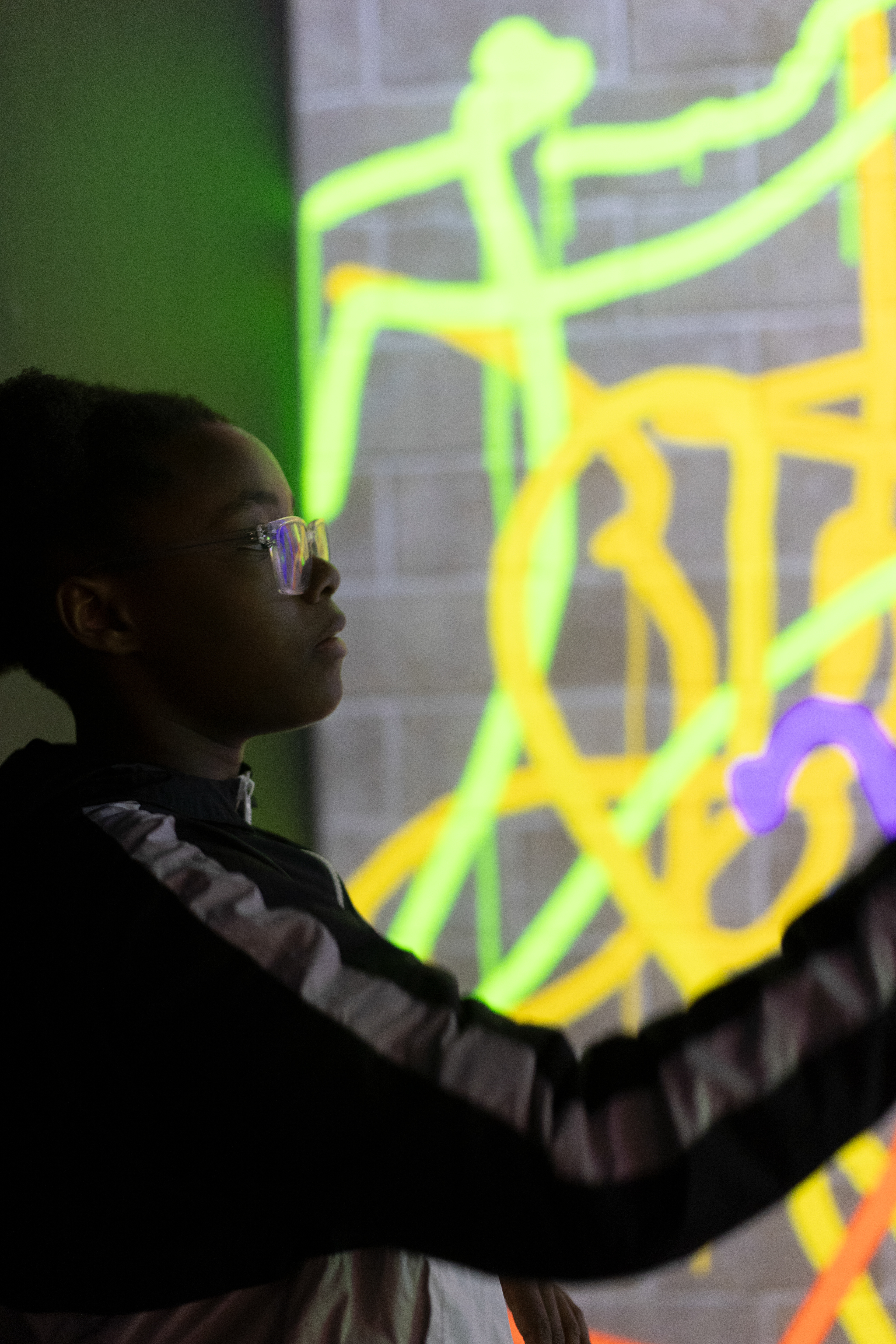 girl drawing on a graffiti wall 