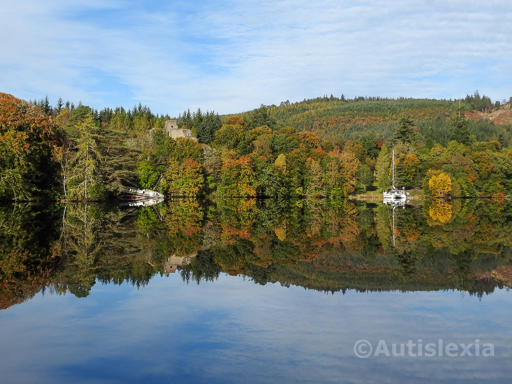 Caledonian canal, boats and trees, in autumn, reflected in the still water