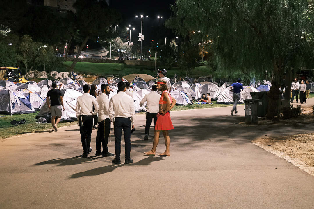 A group of Hasidic Jews talk with a protestor. Jerusalem - 25 July 2023