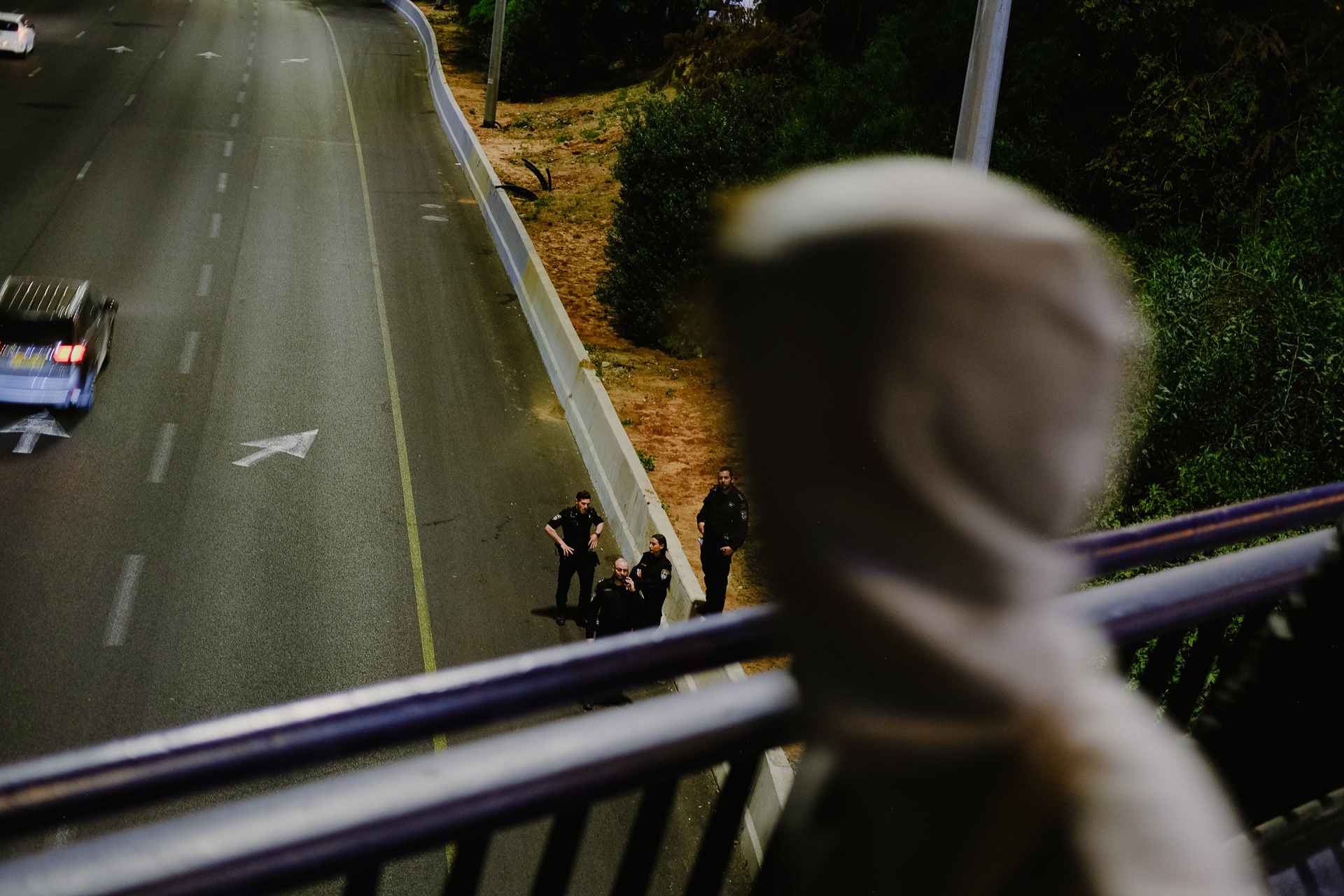 Cops guard the Ayalon highway as a protestor passing a bridge above it. Tel Aviv - 22 April 2023