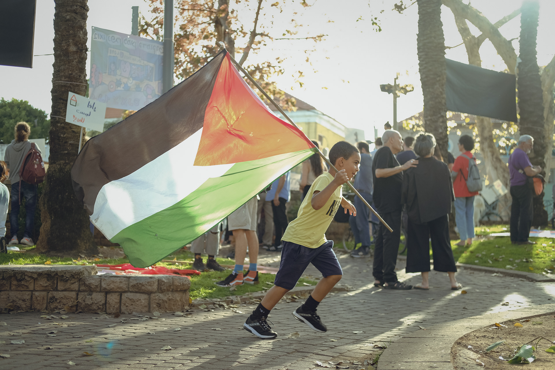 A kid running with a Palestinian flag during a protest against gentrification. Jaffa - 18 May 2023