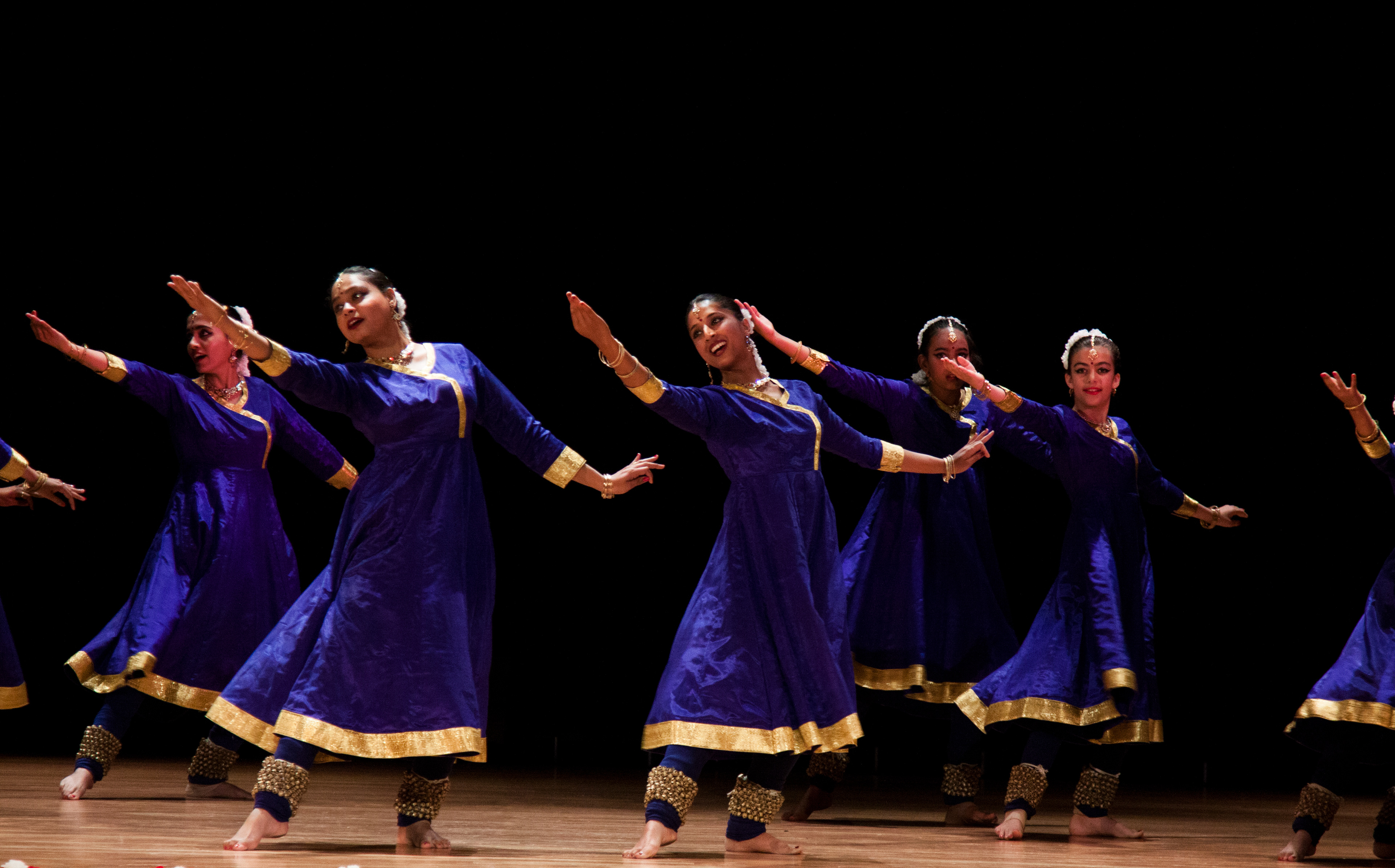 Draped in hues of blue, in a symphony of expressions, Kathak dancers extend an elegant invitation. Smiles adorn their faces as they gaze in unison, reaching out to an unseen presence with a charm that speaks volumes.