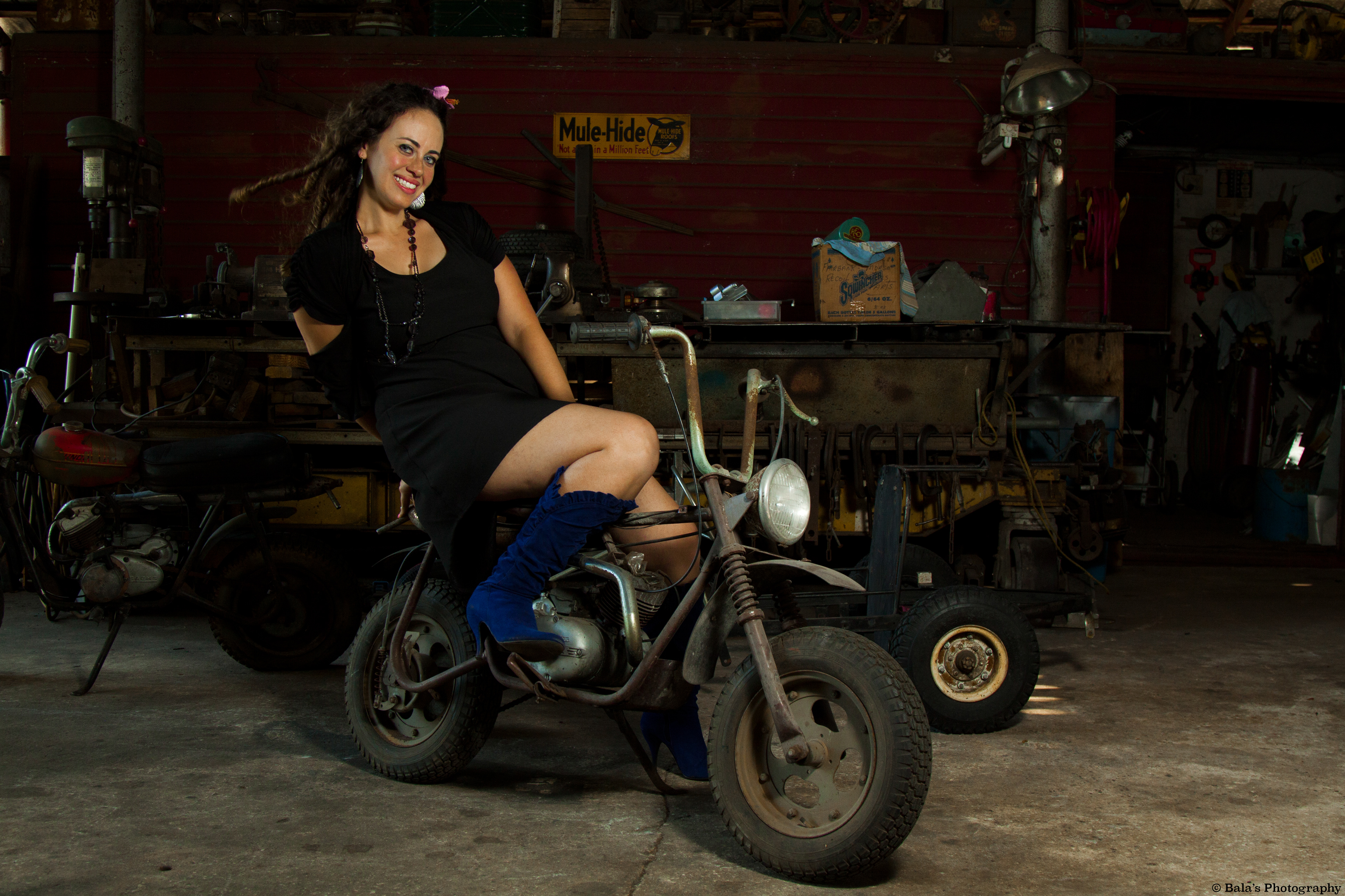 Surrounded by the relics of time, she graces a broken, rusty motorbike within the weathered walls of an old mechanic shop, her cheerful smile becomes a beacon of joy amidst the vintage decay. In the embrace of nostalgia and rust, she radiates an infectious energy that transforms the forgotten into a stage for timeless charisma.