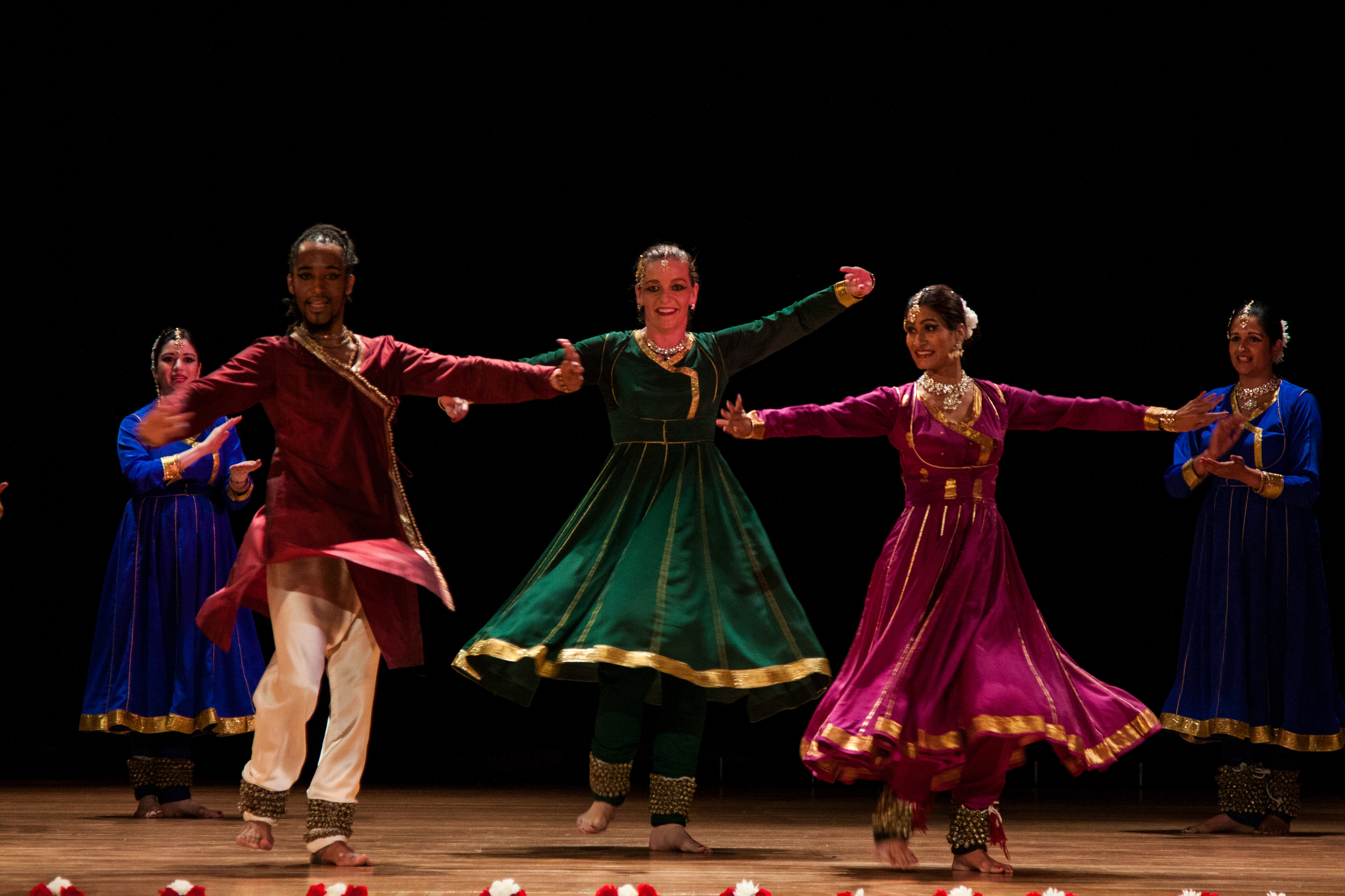In a kaleidoscope of colors, dancers freeze in a mesmerizing whirlwind of spinning motion. Their vibrant attire, like living brushstrokes, paints the air with the beauty of their artistry, capturing the essence of Kathak's dynamic grace.