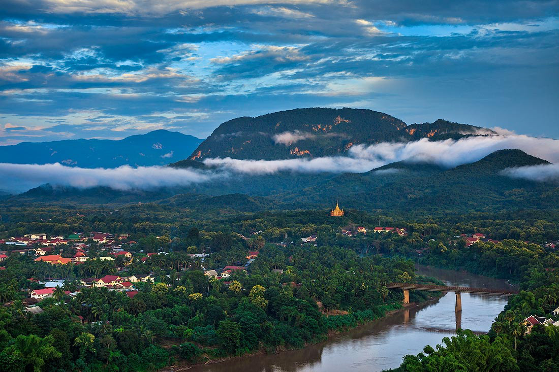Sunset over the Nam Khan River, in the background the temple Vat Phon Pa. Luang Prabang, Laos.