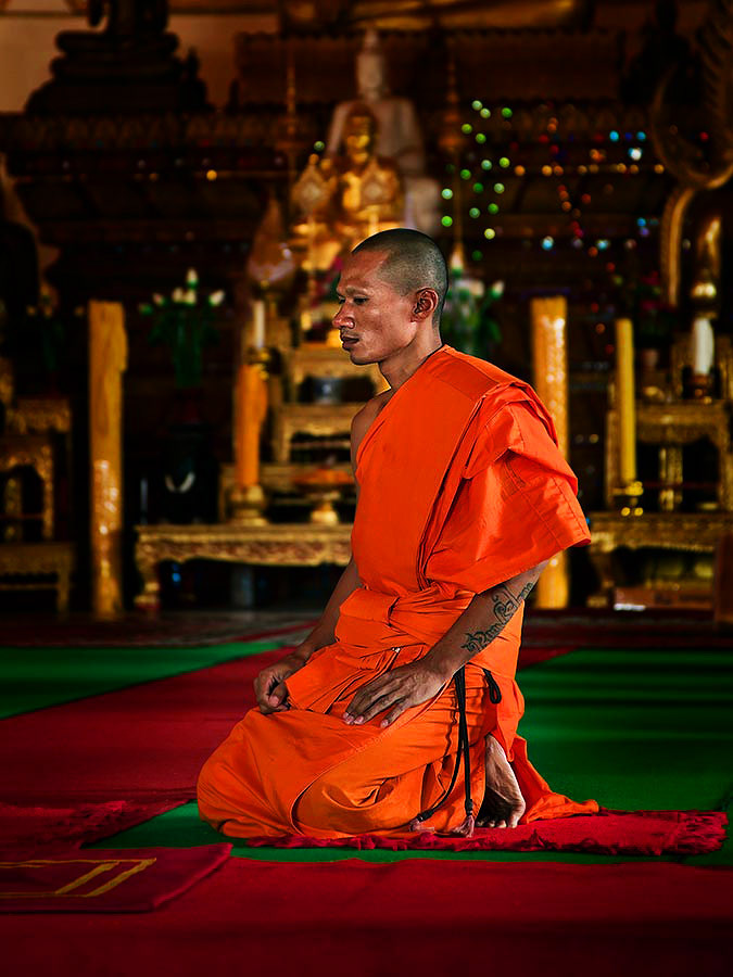 Buddhist monk in one of the temple buildings at the golden stupa Pha That Luang, Vientiane, Laos.