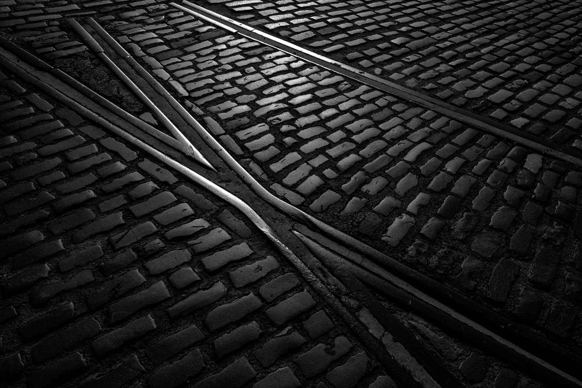 Ref: Hull 20250831_0011. Wellington Street, Kingston Upon Hull, East Yorkshire, United Kingdom, 31 August, 2025. Pictured: Railway lines. During the industrial revolution the railway was king, the lines were often embeded into public roadways were needed, theses rails have fortunatly been retained in the cobelstones leading to the swing bridge crossing the lock pit on Hull’s marina, formally the commercial Humber Dock.