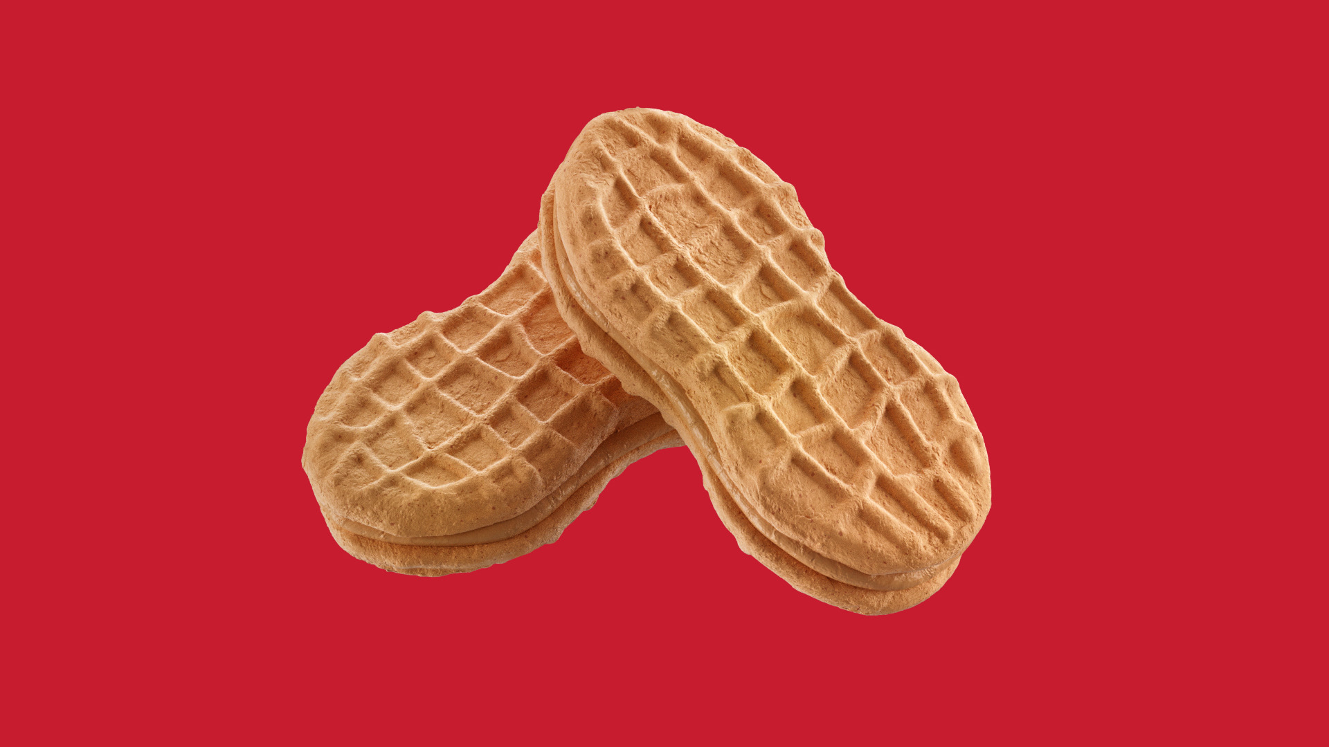 Two peanut-shaped cookies stacked together against a red background.