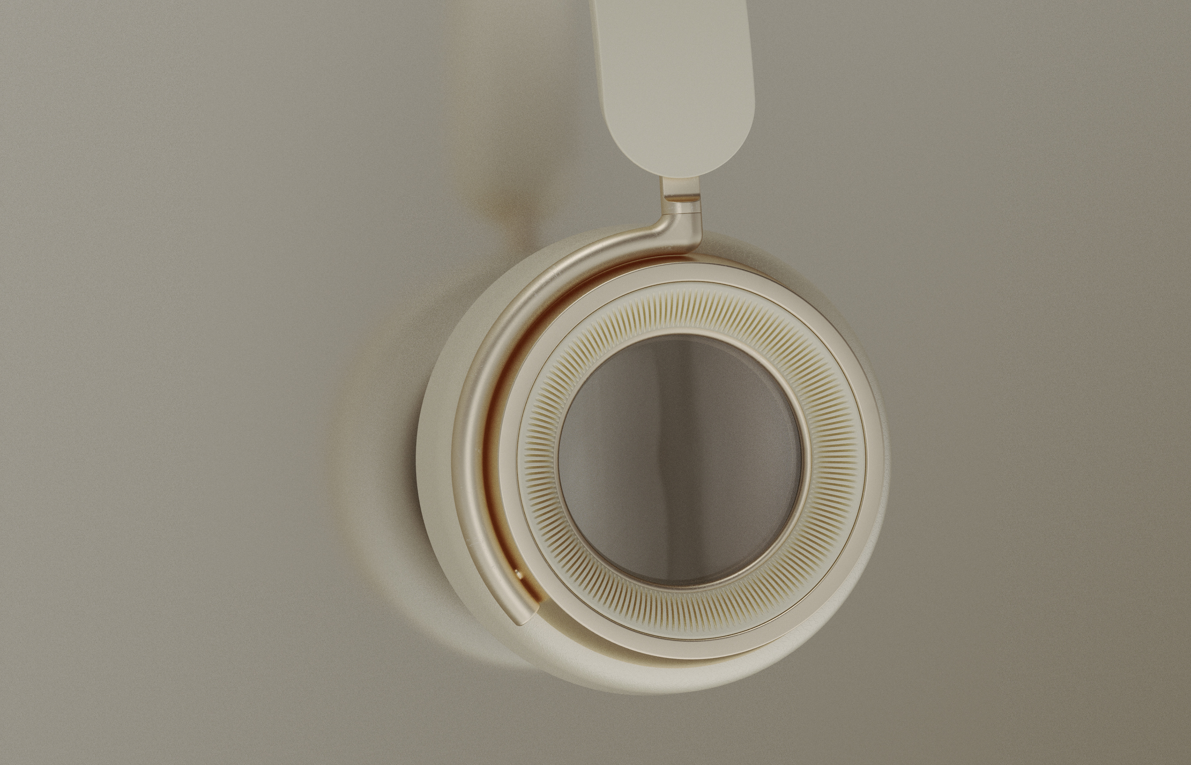 Close-up of an elegant beige and gold over-ear headphone earcup, showcasing its intricate design and premium materials against a neutral background.