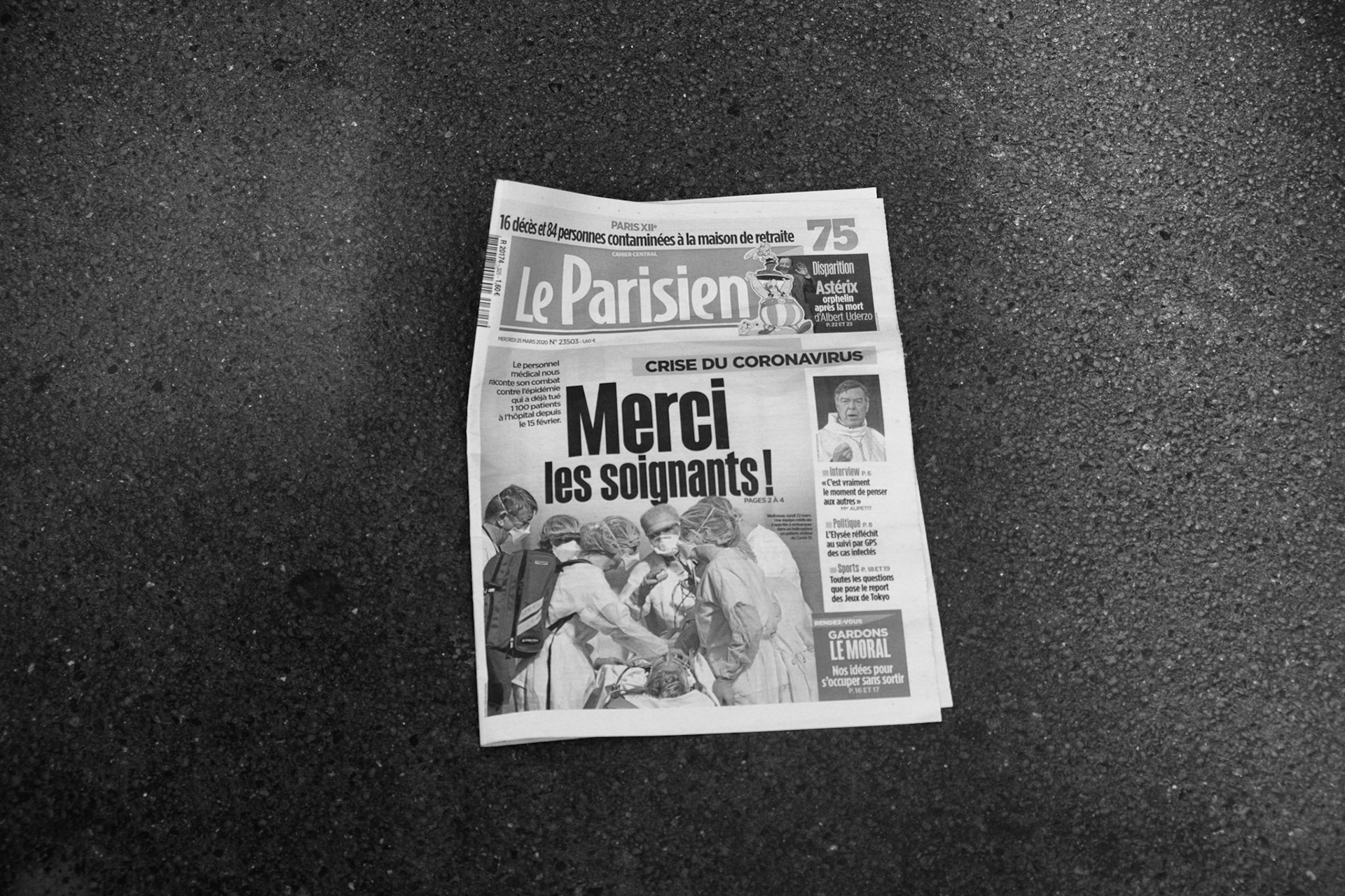 Vendredi 27 mars 2020. Les rues ne sont plus que patiellement nettoyée, on trouve des journeaux au milieu de la route. Le parisien du 25 mars rend hommage aux soignants.