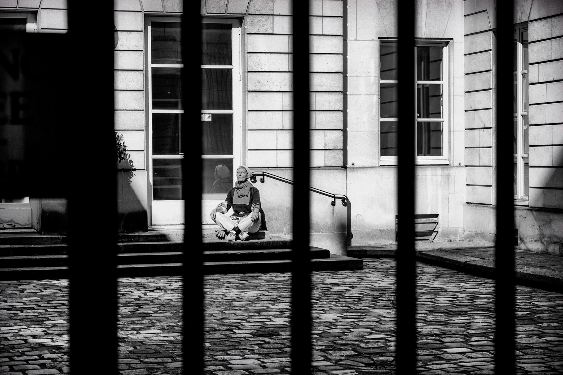 Dimanche 5 avril 2020. Derrière les grilles d'une cour intérieure je vois cette femme qui semble méditer. Tout me paraît serein soudainement.