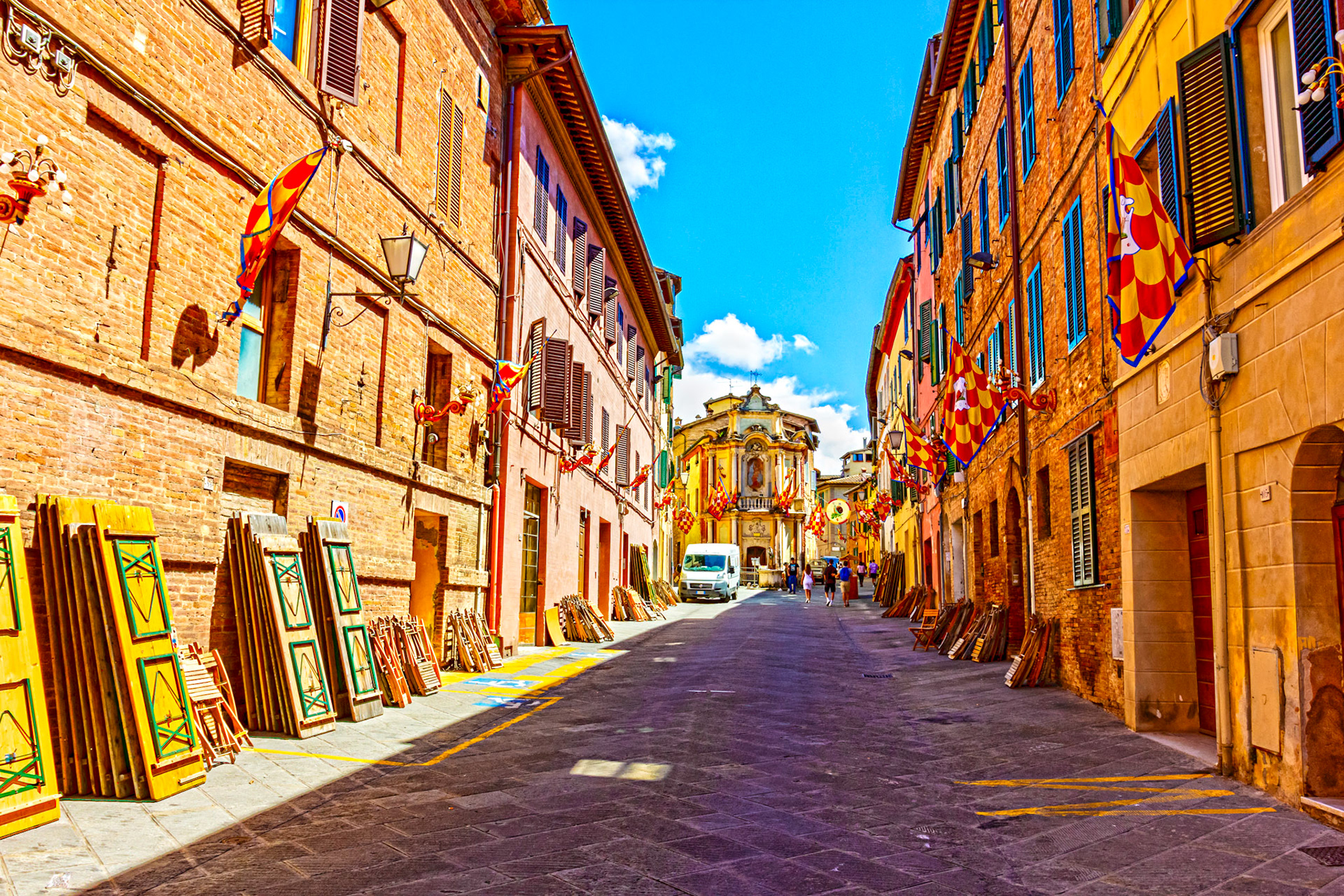 Street scene in Siena with Palio decorations and prep for street meal - 26 June 2024