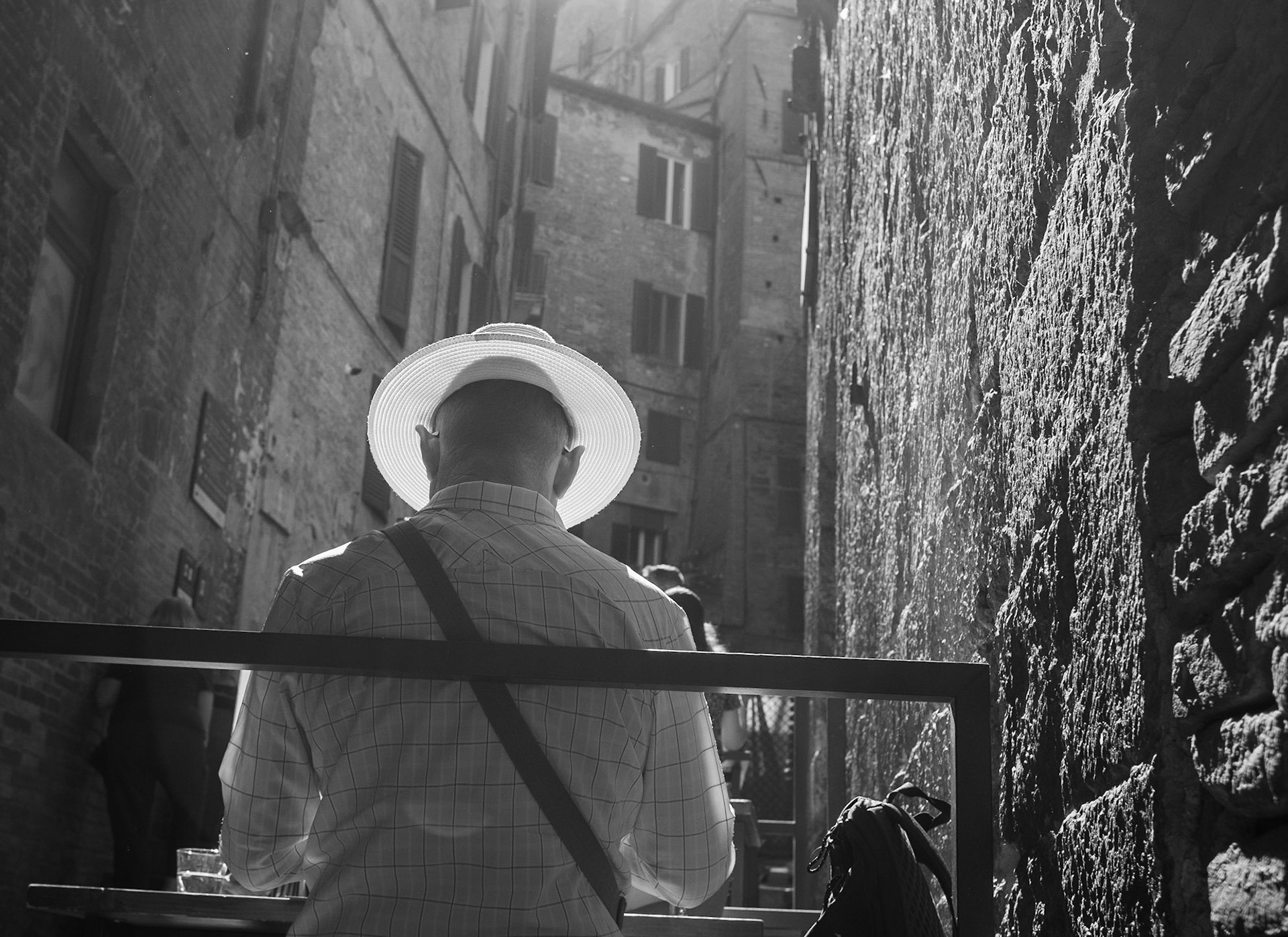 Sunlight hits a man's hat in Siena, Italy