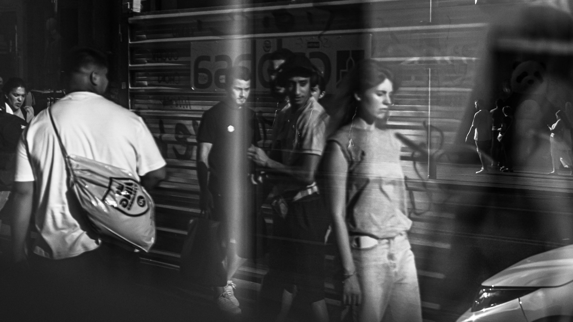 Surrounded by curious gazes, she stands in the spotlight, momentarily transformed into a celebrity by the act of being observed. The reflections frame her like an unintentional icon — a figure of intrigue, though unknown and ordinary. In this fleeting moment, the camera bestows fame upon the unnoticed, turning the mundane into the extraordinary.