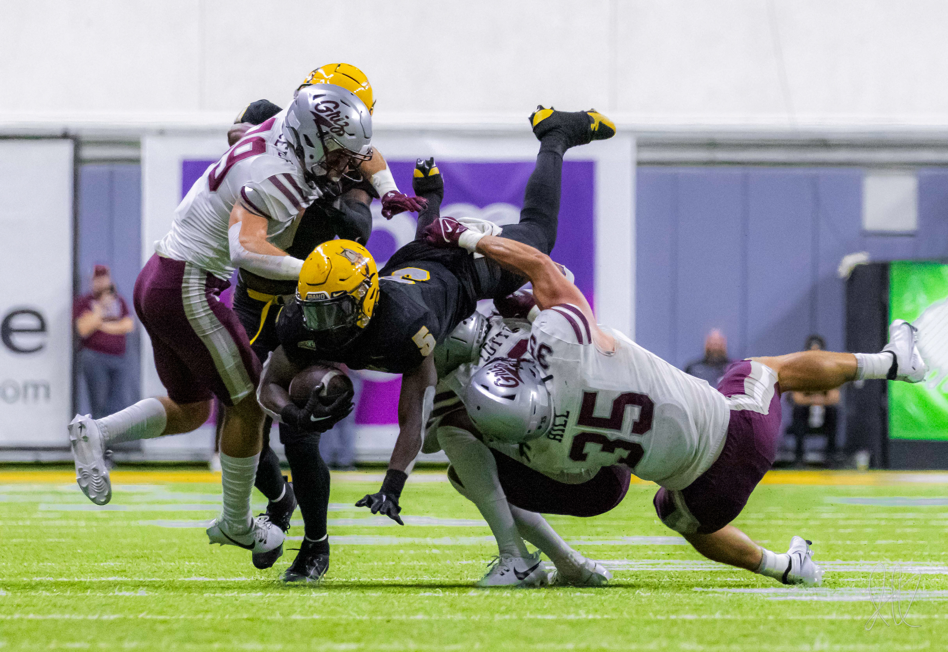 Anthony Woods dives over defenders, attempting to pick up a first down