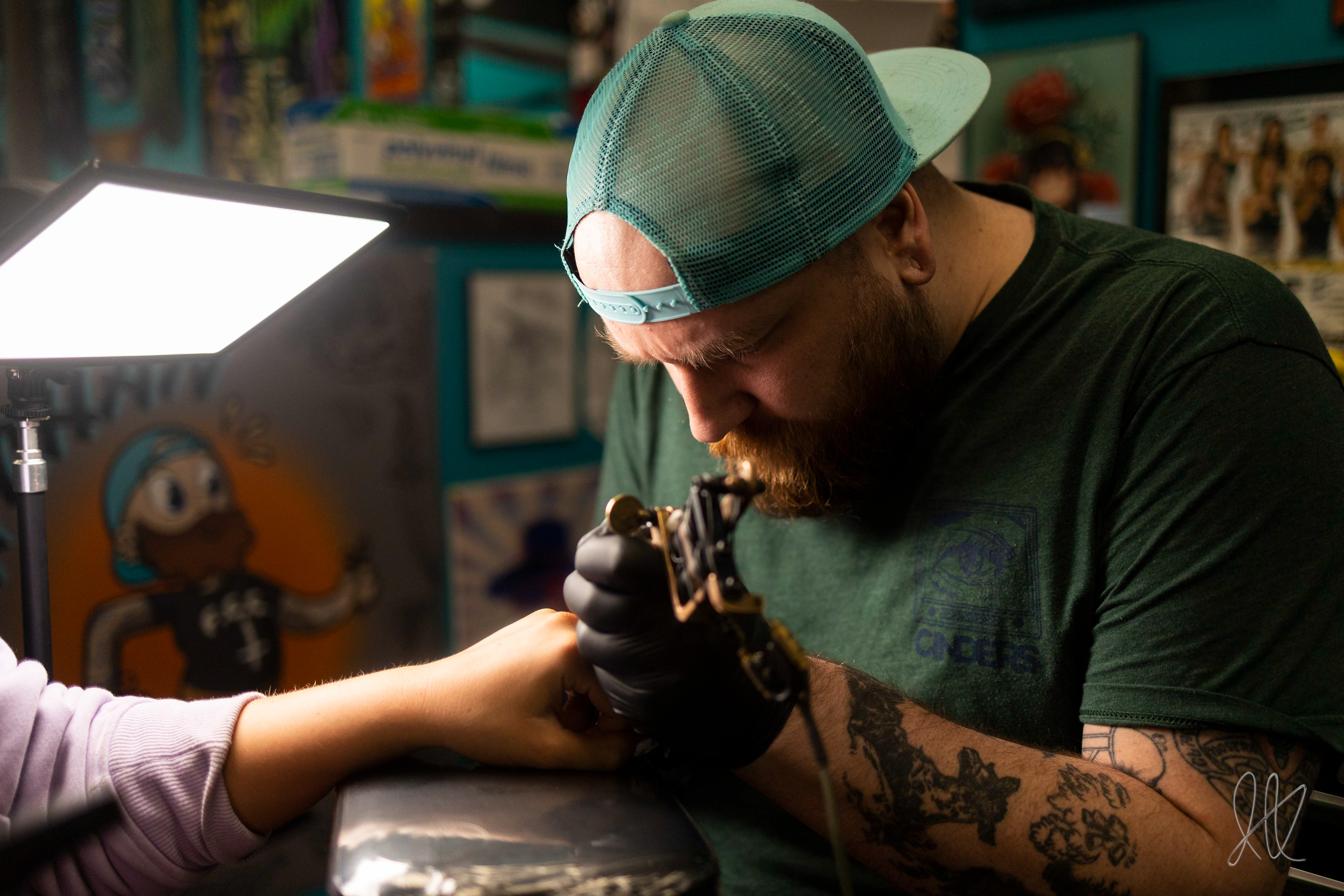 Brad Sheets diligently touching up a client’s finger tattoo at Moscow Tattoo Company, Best of Moscow "Best Tattoo Shop"