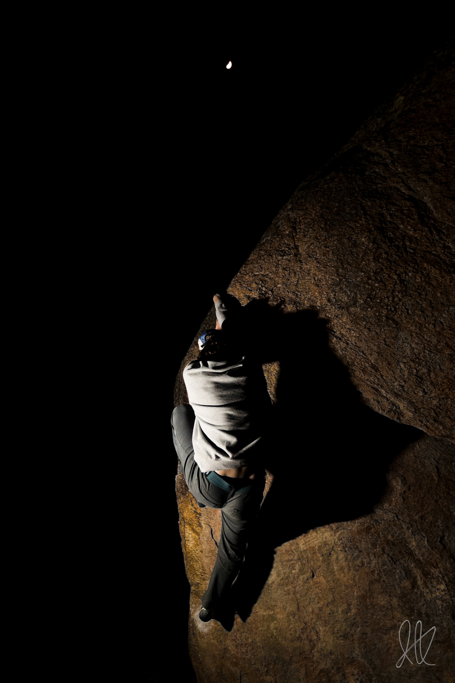 Ian Kolaja hangs on the edge of an arete under the moon