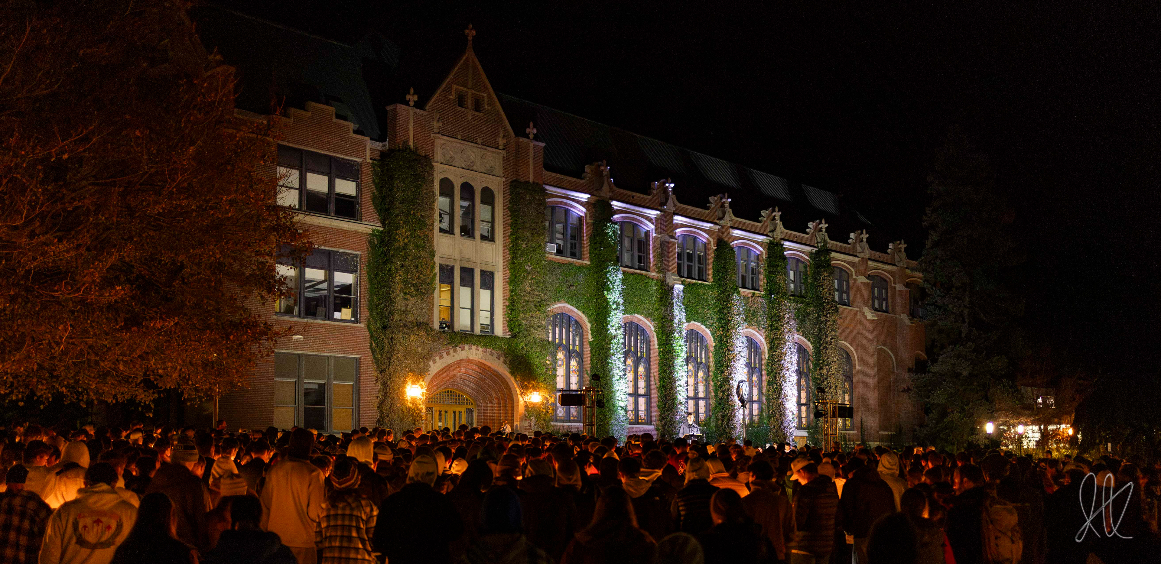 ASUI President Tanner McClain address the crowd of attendees at the candlelight vigil, standing under four beams of light representing the four lives lost