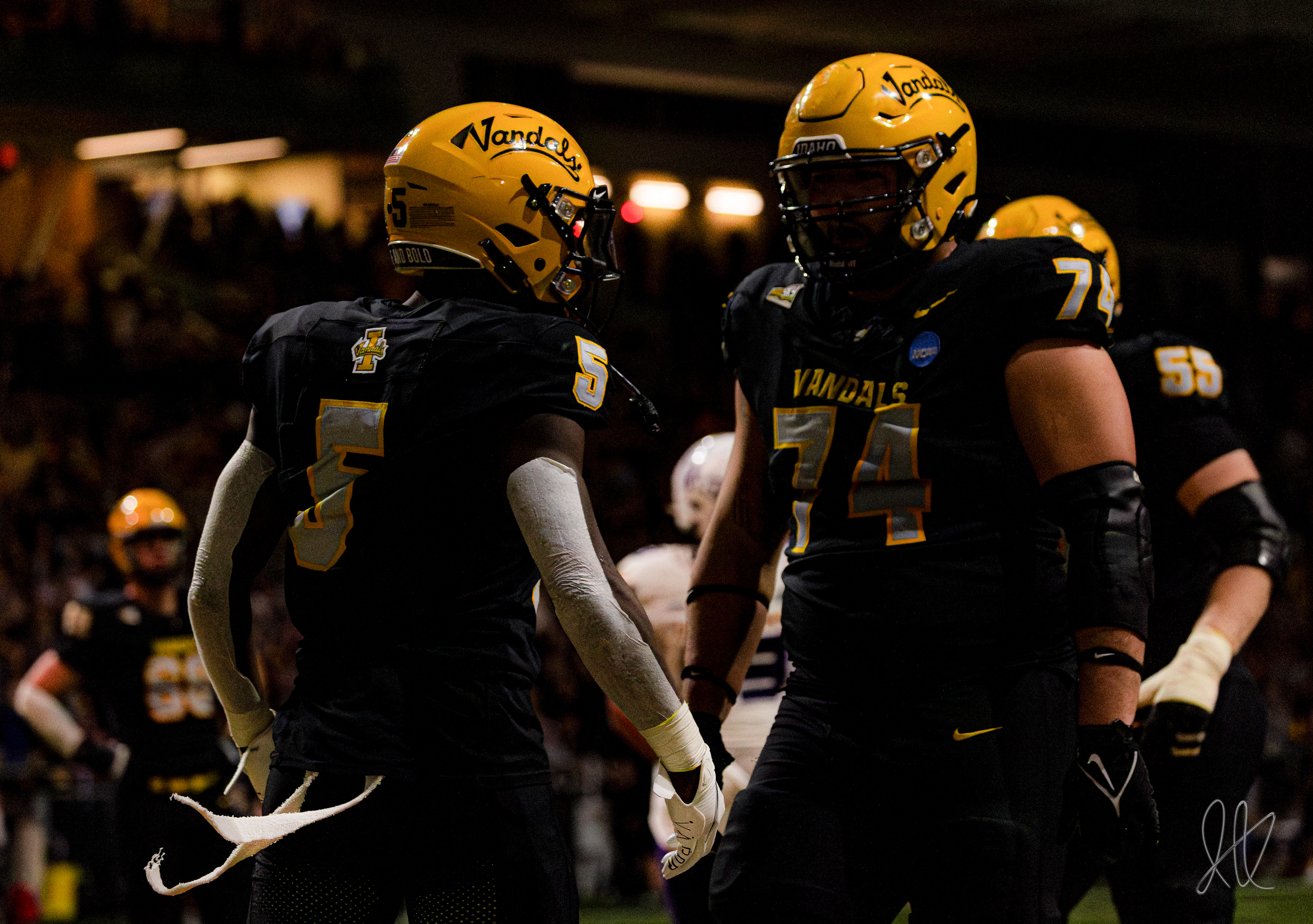 RB Anthony Woods (left) celebrates with OL Nate Azzopardi under the flashing lights of the Kibbie Dome
