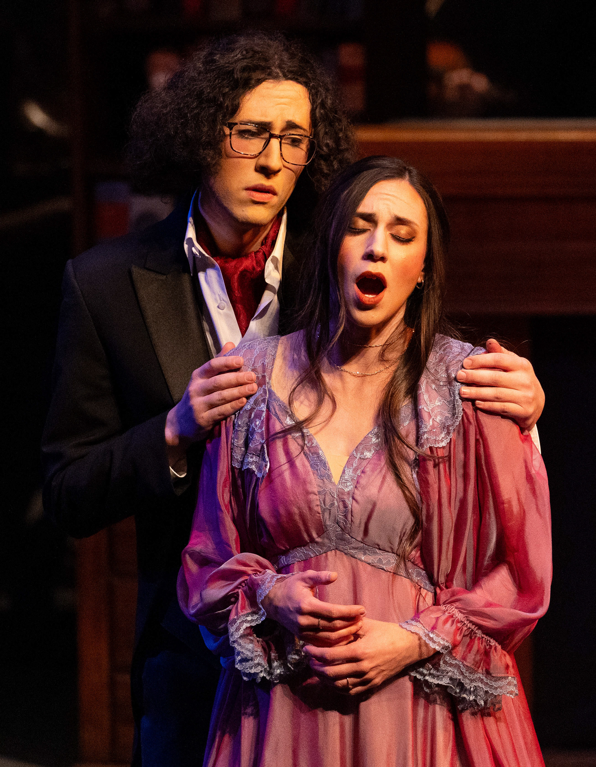 Rosalinde (played by Mikaila Calhoun) feigns sadness in her song while her husband (played by Samuel Marcus Leeper) embraces her in a University of Idaho performance of Die Fledermaus. March 2, 2024. (Argonaut/John Keegan)