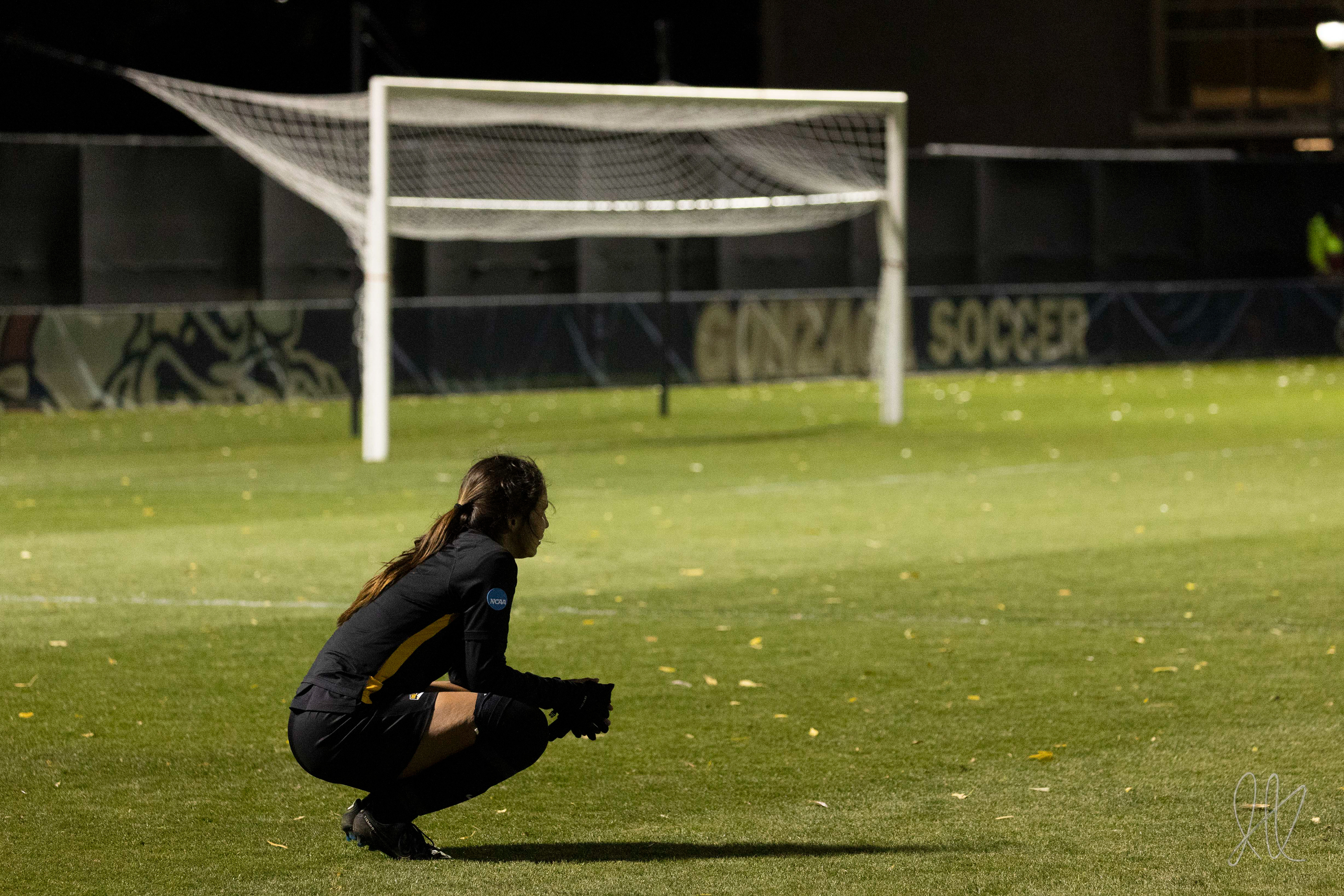 Hannah Alfaro squats on the field after potentially the last game of her college career,  at Gonzaga