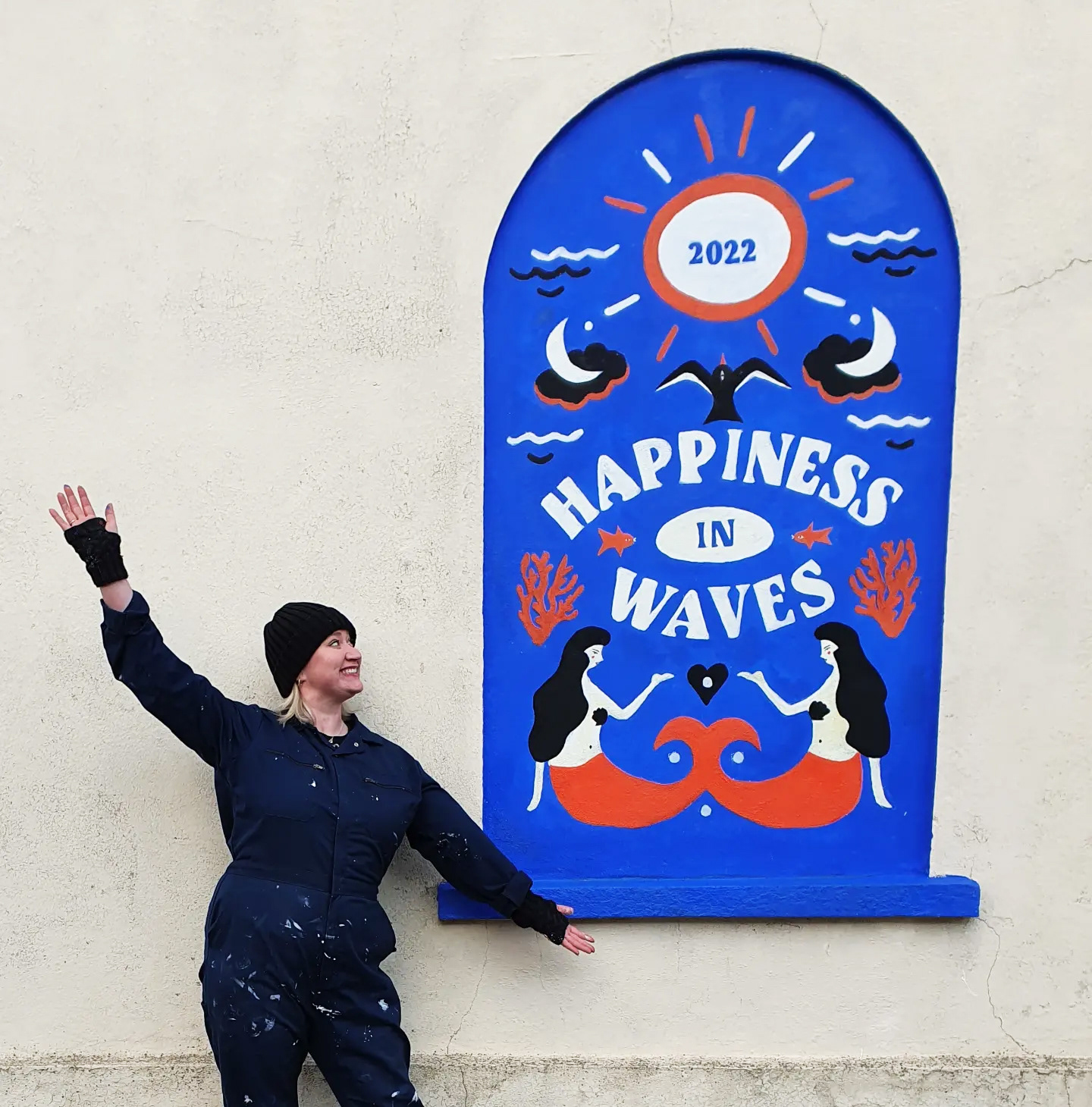 Serena June Creative standing under her Happiness In Waves Mural