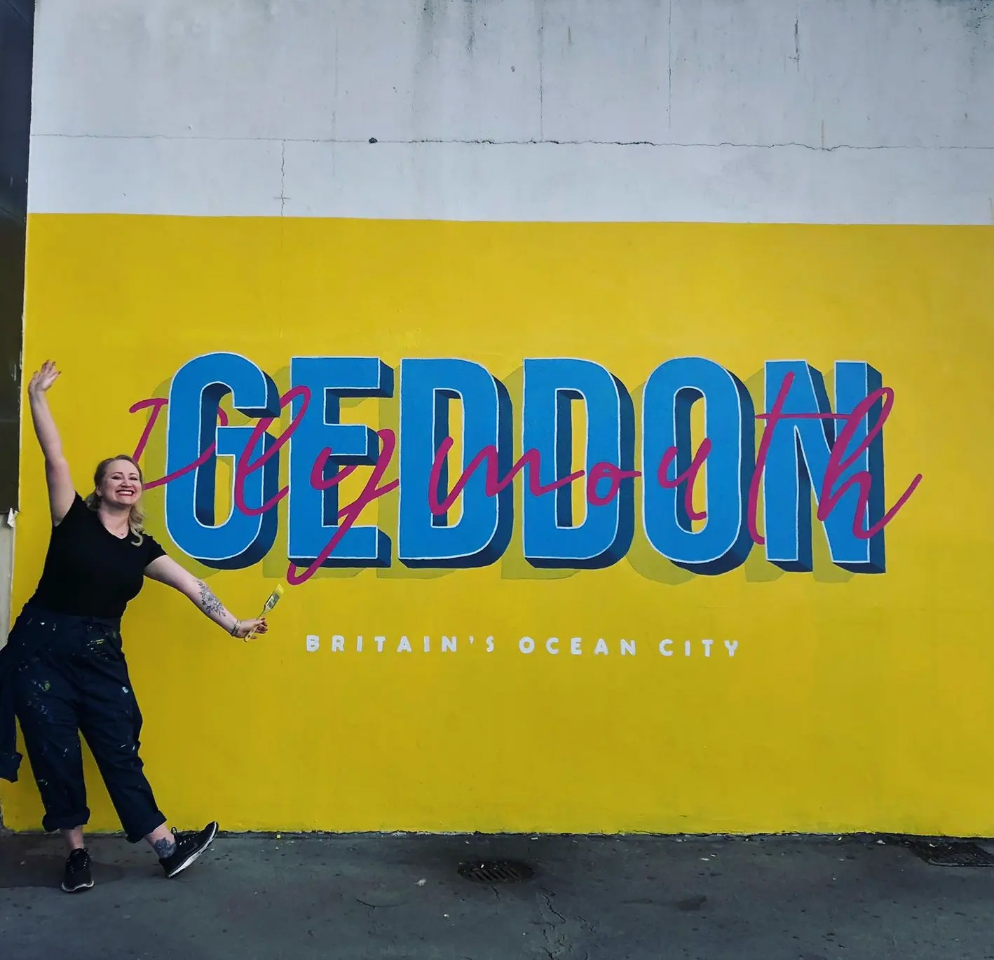 Serena June in front of her Geddon Plymouth Mural