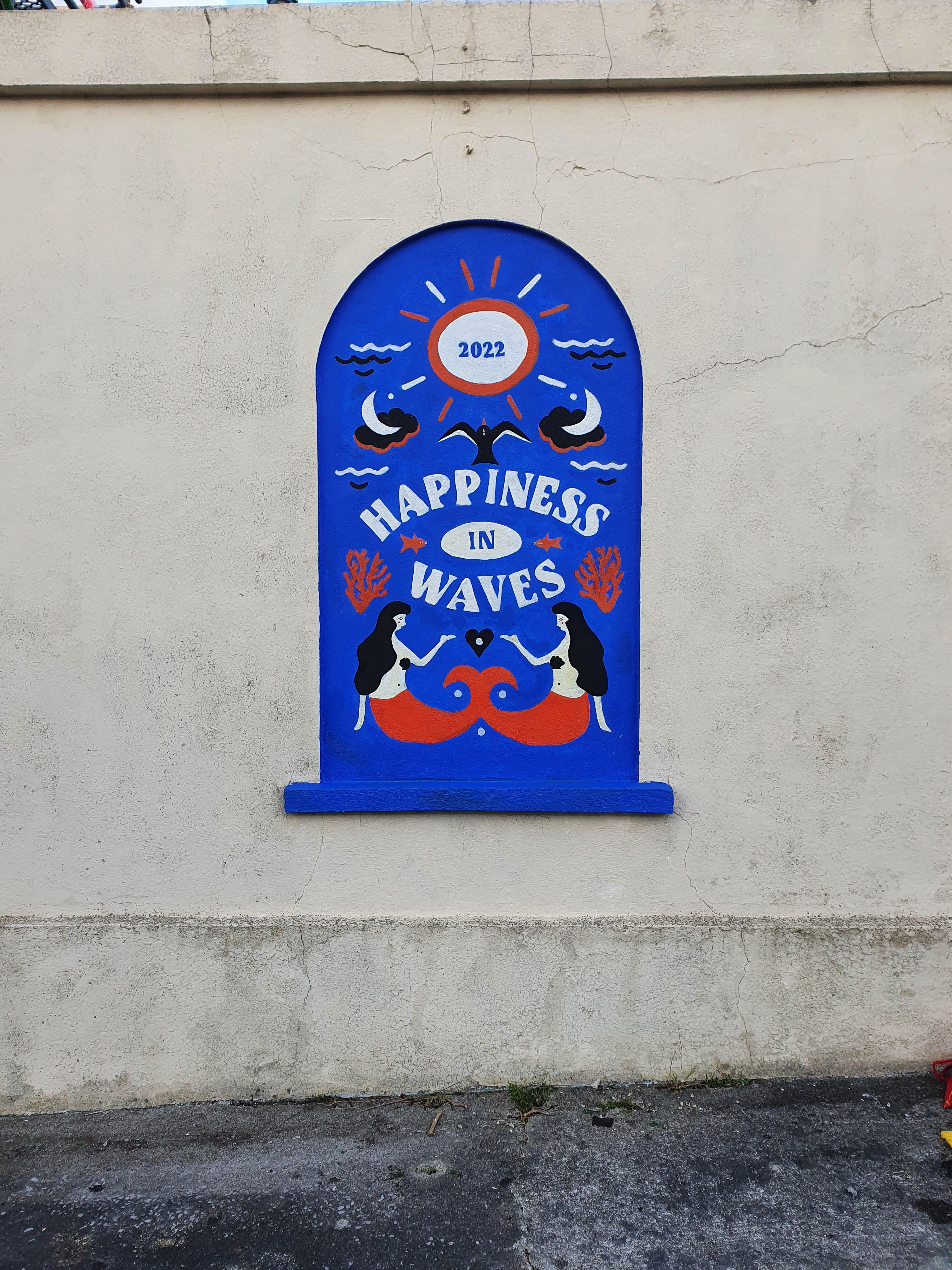 A bold blue mural by Serena June Creative with the text Happiness in waves