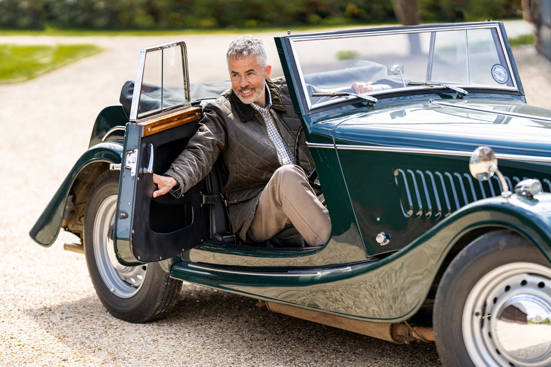 Man in country jacket sitting in vintage car, capturing essence of lifestyle fashion photography