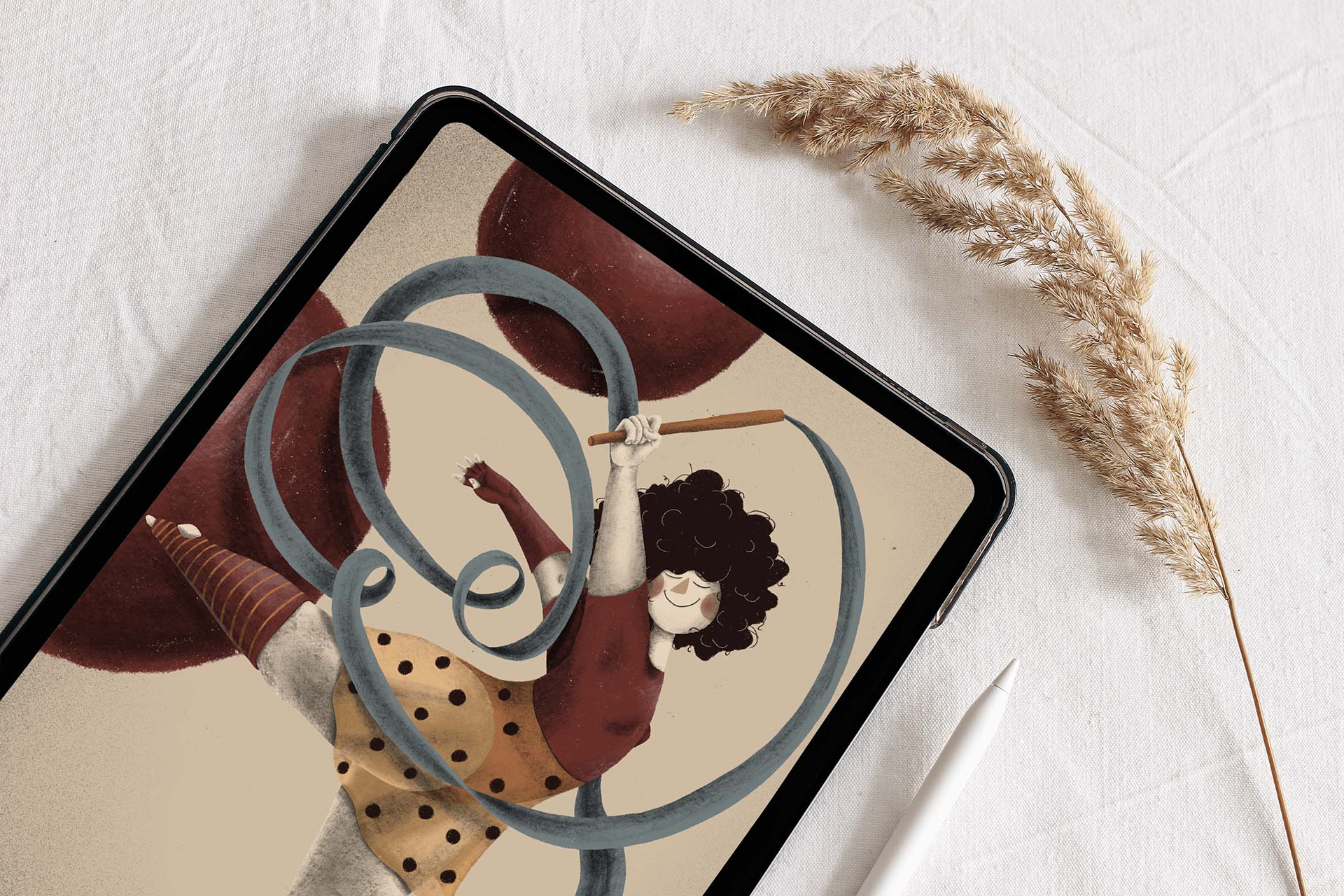 Digital illustration by Darka White of a whimsical dancer with curly hair, twirling a ribbon in joyful motion, displayed on a tablet screen. The dancer wears a polka-dotted skirt and a red top, set against a neutral background with warm red accents. The tablet rests on a white fabric surface beside a dried wheat stem and a white stylus.