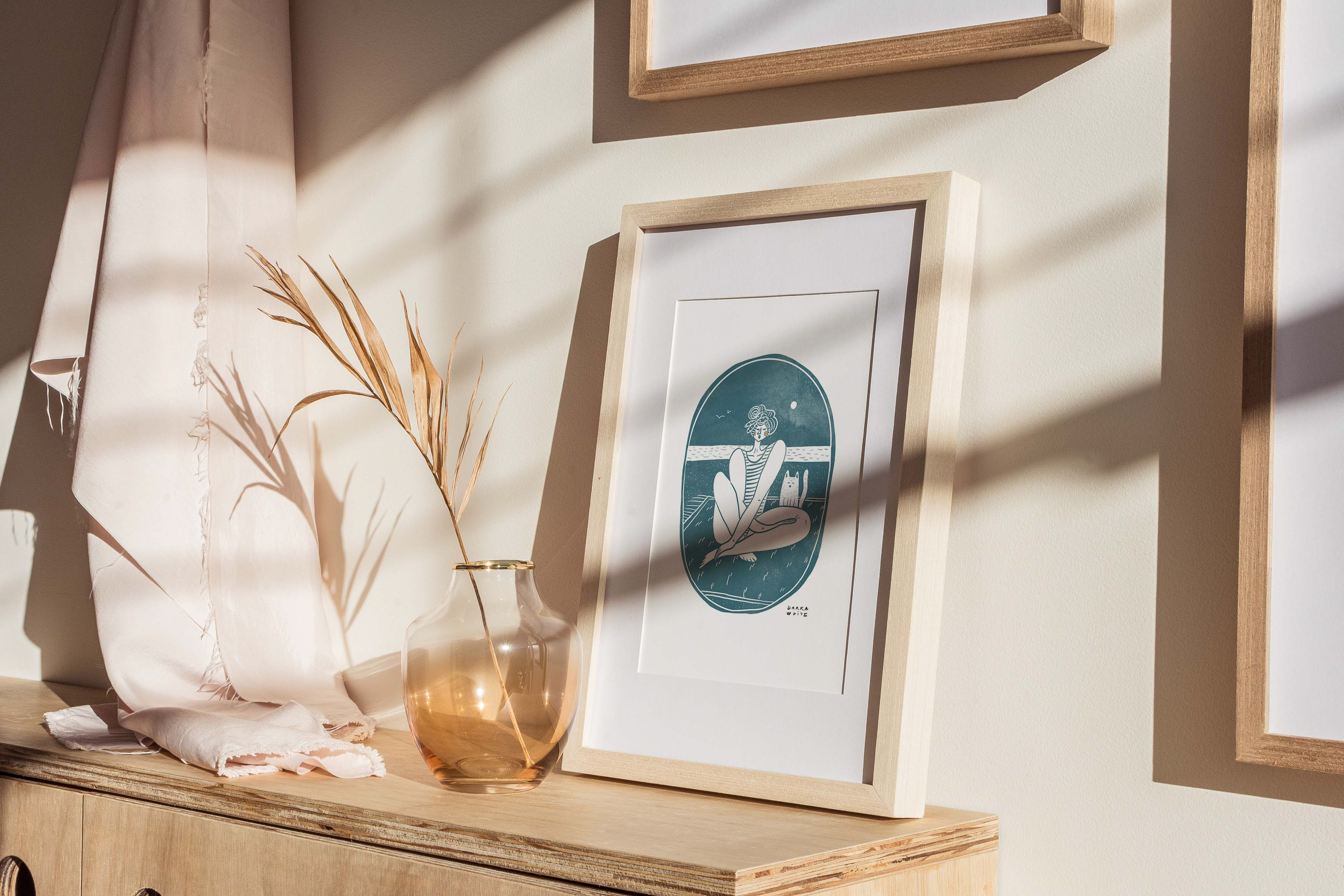 Framed contemporary illustration of a woman and her cat in a serene setting, perfect for home decor. Illustration by Darka White Krizman.