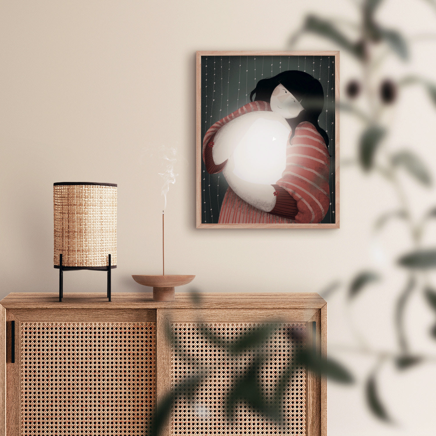 Framed illustration titled 'The Way to Self' by Darka White Art, depicting a person in a striped sweater hugging a ball of light with a backdrop of delicate, starry strings, displayed in a cozy room on a woven-front sideboard, evoking self-love and warmth.