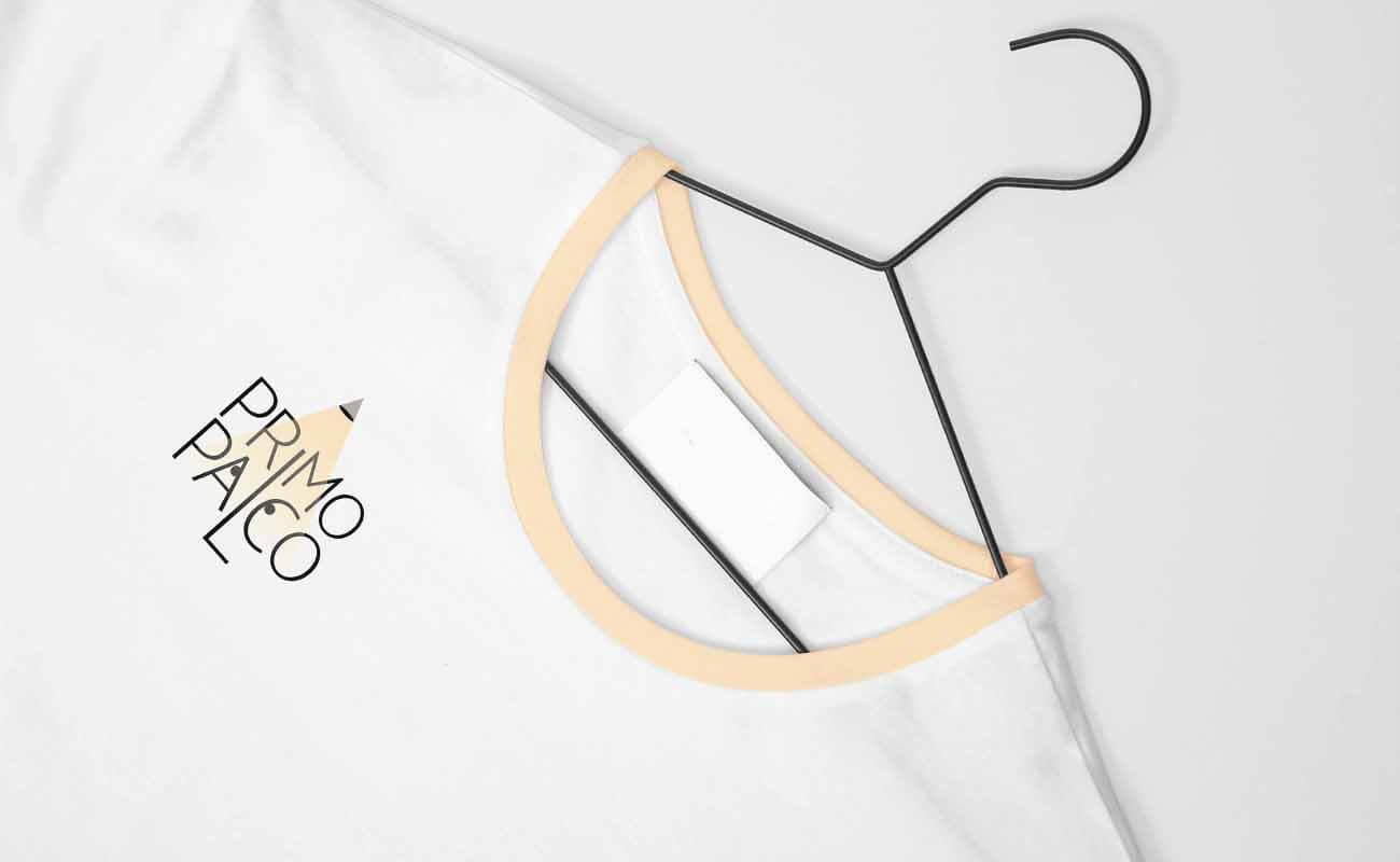 Primo Palco logo designed by graphic designer Darka White, featured on a t-shirt, with a spotlight as the dot on the 'I' and eyes within the 'a' and 'c' of 'palco' to symbolize stage visibility for young talents.