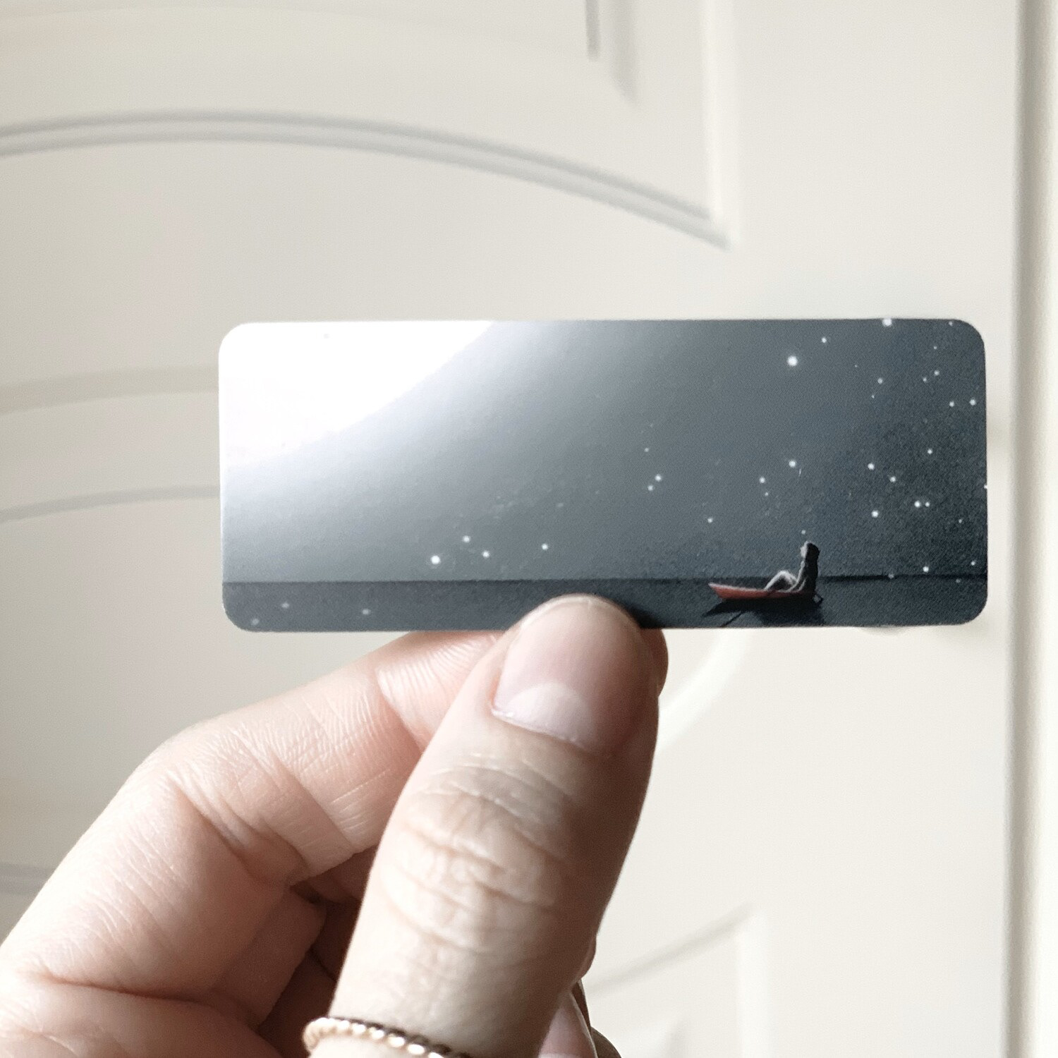 Back side of Darka White's business card featuring an illustration of a person in a boat under a starry night sky, showcasing the artistic and creative style of graphic designer and illustrator Darka White.