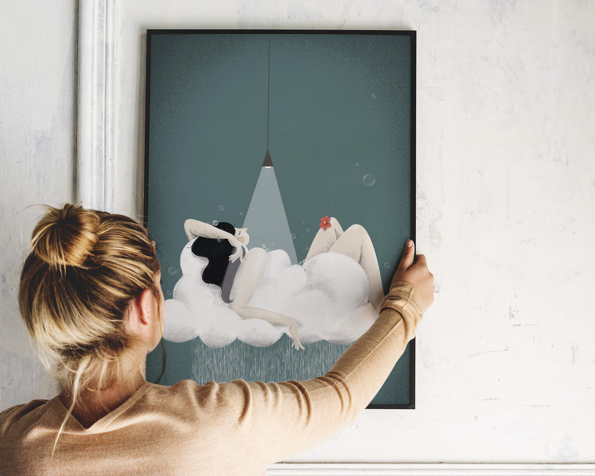 Woman holding a framed art print of 'Recharge Marghe' – a serene, nature-inspired illustration featuring a woman resting on a cloud under a spotlight, designed by Darka White Art