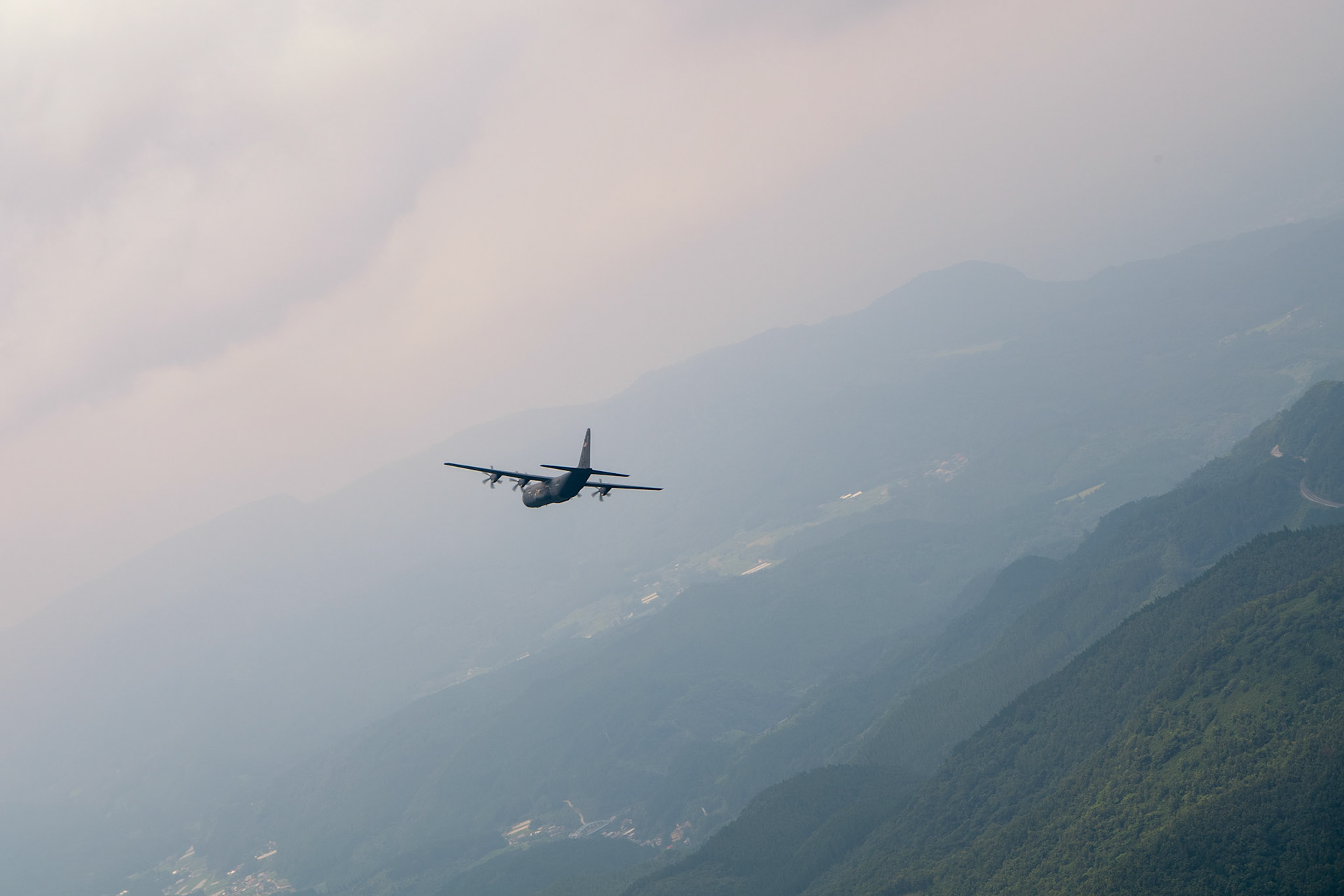 A U.S. Air Force C-130J Super Hercules assigned to the 36th Airlift Squadron conducts flight training over Mount Aso, Japan, July 16, 2019, during a bilateral jump training. The training allows USAF and JGSDF units to work alongside each other while improving the readiness of our armed forces.
