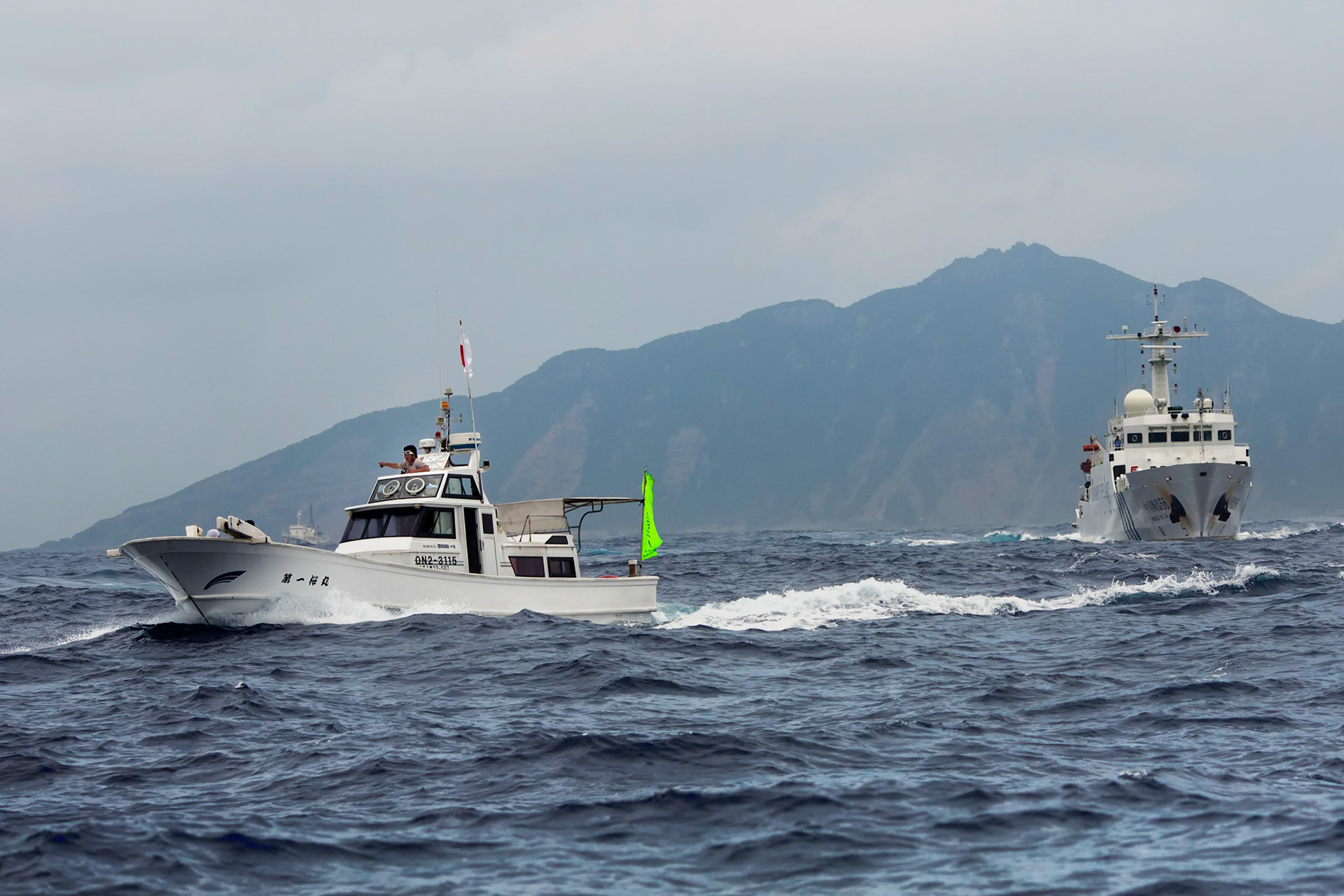 SENKAKU ISLANDS, Japan -- The Chinese maritime surveillance ship Haijian No. 66 pursues a Japanese commercial fishing boat at Uotsuri-jima, May 26, 2013. Chinese government ships entered into the Japanese territorial waters of 46 times. (Photo by Osakabe Yasuo)