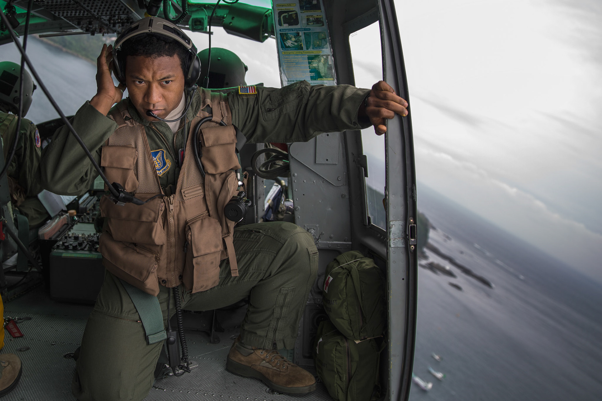 Maj. Zensaku Munn, 374th Operations Support Squadron air mobility liaison officer, listens to the radio over Shimoda bay, Shizuoka prefecture, Japan, Aug. 31, 2014, during the Shizuoka Comprehensive Disaster Drill. Munn relayed drop clearance to the inbound C-130 Hercules from a UH-1N Iroquois during the drill. (U.S. Air Force photo by Osakabe Yasuo/Released)