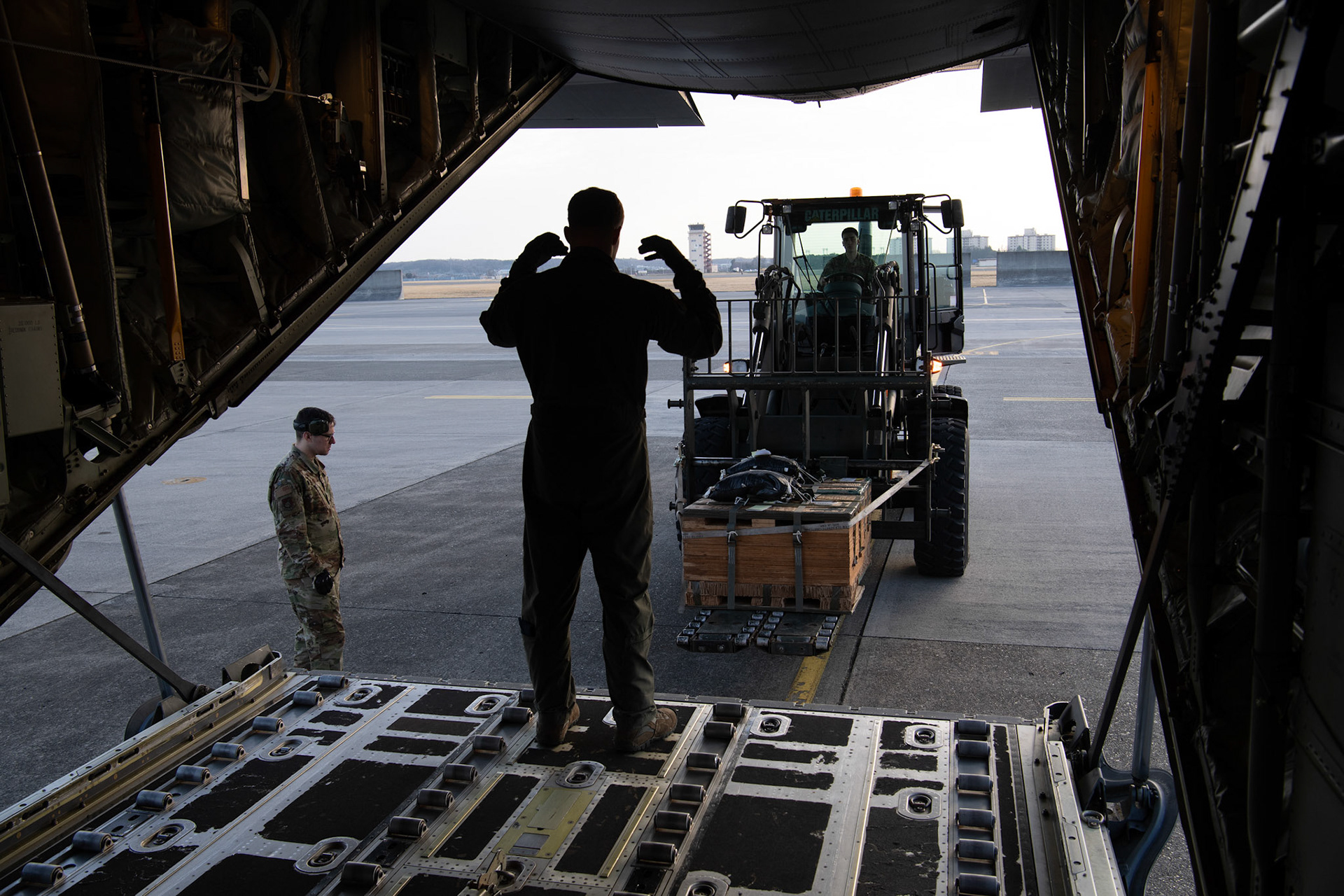Airman 1st Class Matthew Pfeffer, 36th Airlift Squadron C-130J loadmaster, marshals a forklift during the Yokota C-130J Rodeo at Yokota Air Base, Japan, March 22, 2019. The flight, airdrop, and offload were a part of the Rodeo competition in which pilots and loadmasters are graded on their ability to execute their skillsets both accurately and expeditiously. (U.S. Air Force photo by Yasuo Osakabe)