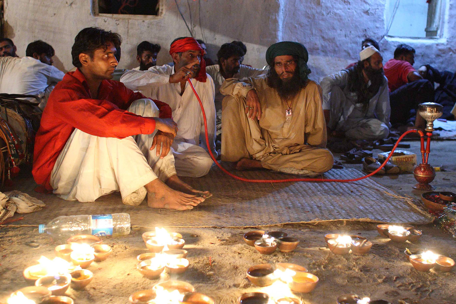 Devotees in a relaxed mood with Hookah, means water pipe in Urdu, at their pilgrim encampment. (Travel)