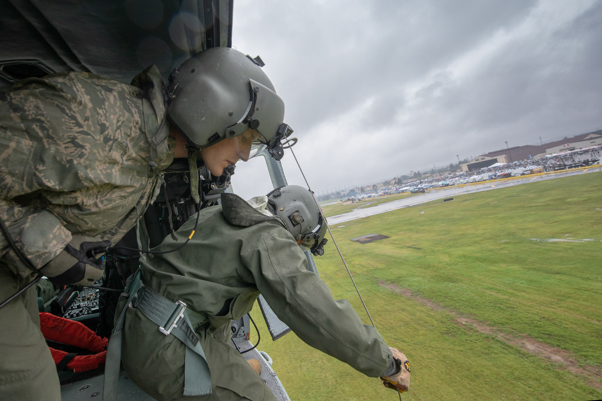 (Left to right) Tech. Sgt. Dustin Sheffield, 459th Airlift Squadron UH-1N standardized and evaluation flight engineer, communicates with Tech. Sgt. Nicholas Poe, 459th AS special mission aviator, to guide down a hoist during a Capabilities Exercise as part of the 2018 Japanese-American Friendship Festival at Yokota Air Base, Japan, Sept. 15, 2018. Members with the 459th AS showcased their rescue capabilities to execute search-and-rescue mission. (U.S. Air Force photo by Yasuo Osakabe)