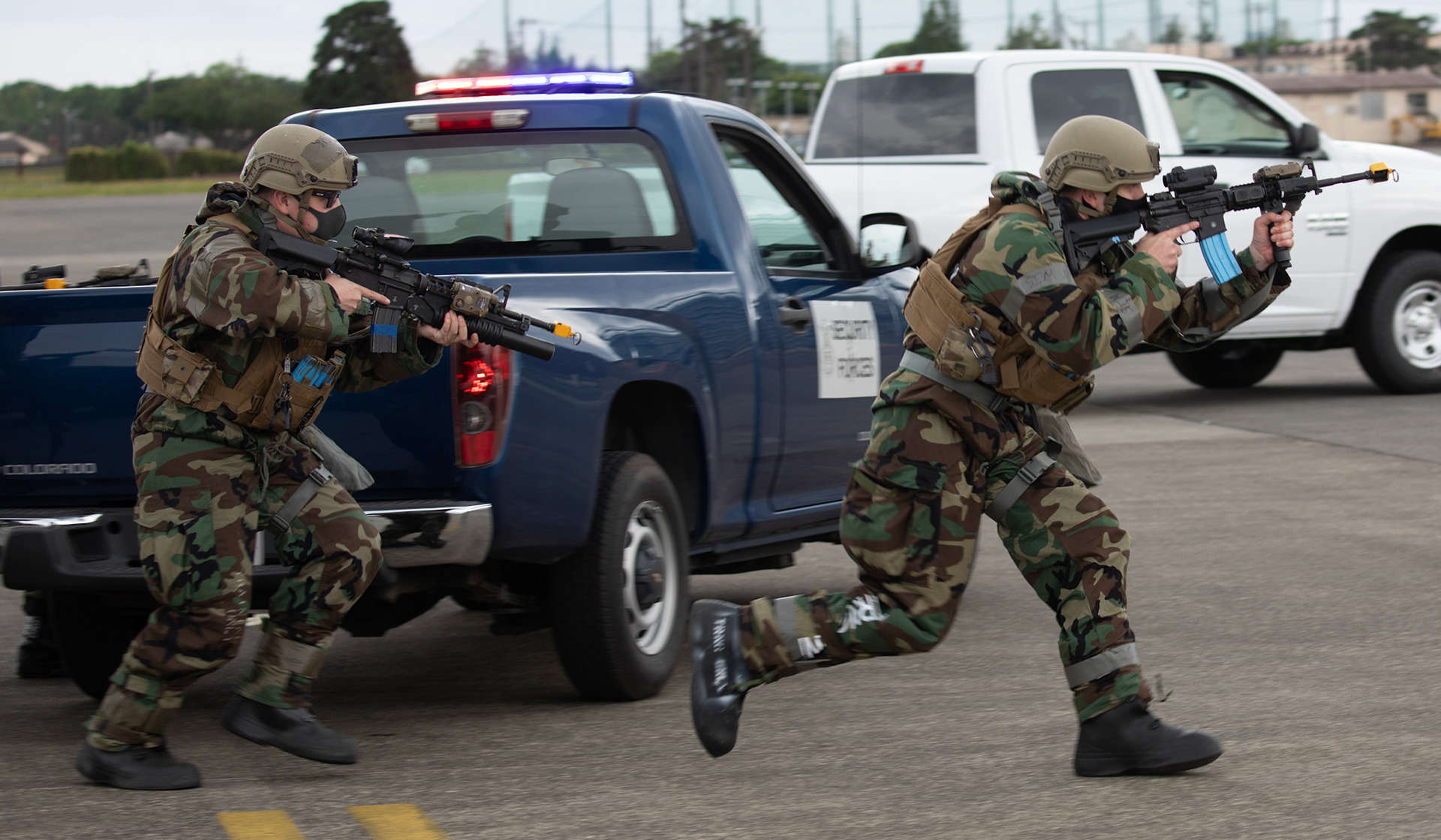 (Right to left) Airman 1st Class John Maclean and Dominic Allen, 374th Security Forces Squadron patrolmen, approach a C-12 Huron in attempt to secure the plane after being "hijacked" during an anti-hijacking exercise on the flightline at Yokota Air Base, Japan, May 5, 2021. Team Yokota members participated in a two-week-long Samurai Readiness Inspection exercise which ensures the base is ready to respond to potential contingencies in the area. (U.S. Air Force photo by Yasuo Osakabe)