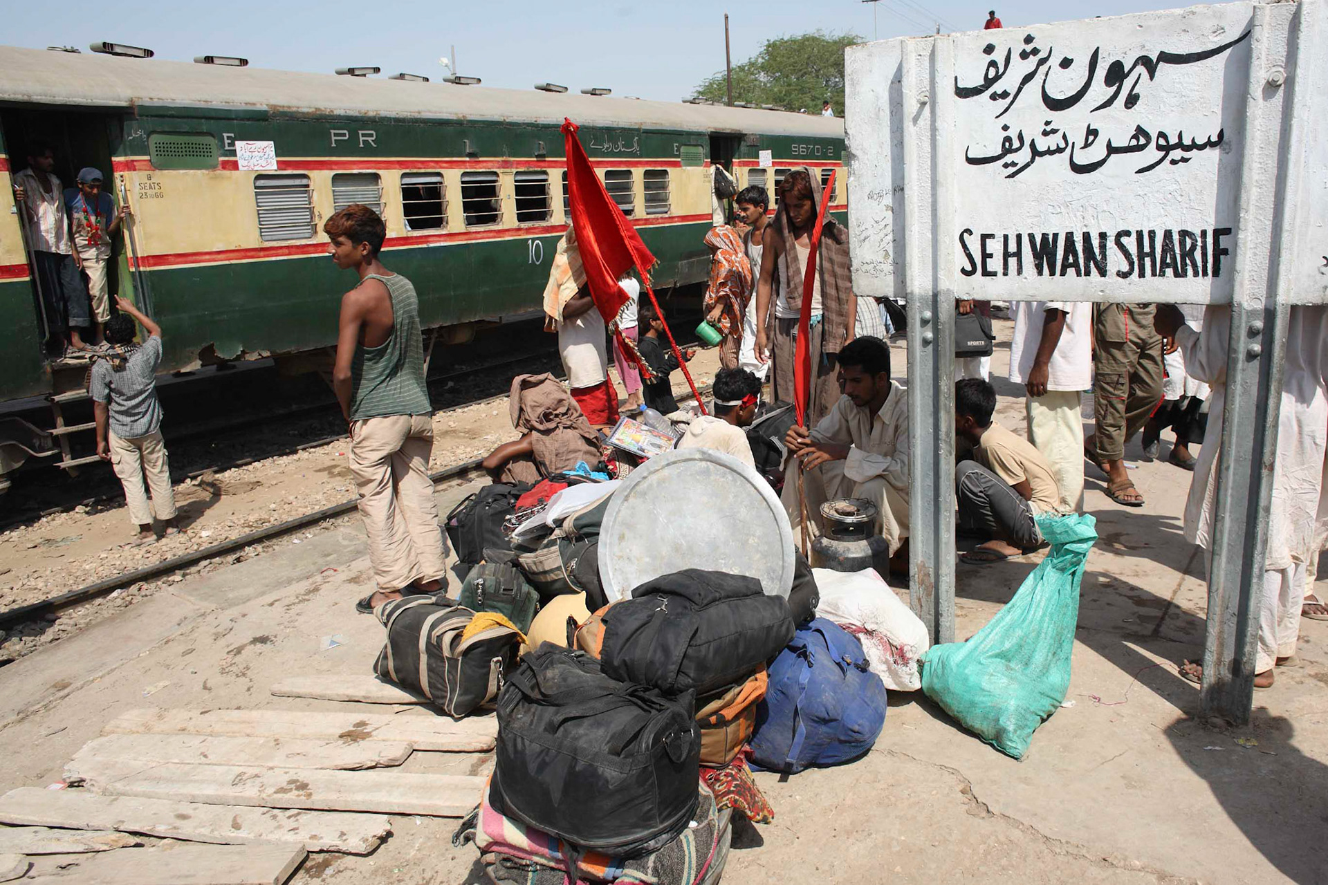 Devotees were going back home with the red flag. The red flag represents that devotees visited the tomb of Lal Shahabaz Qalandar. (Travel)