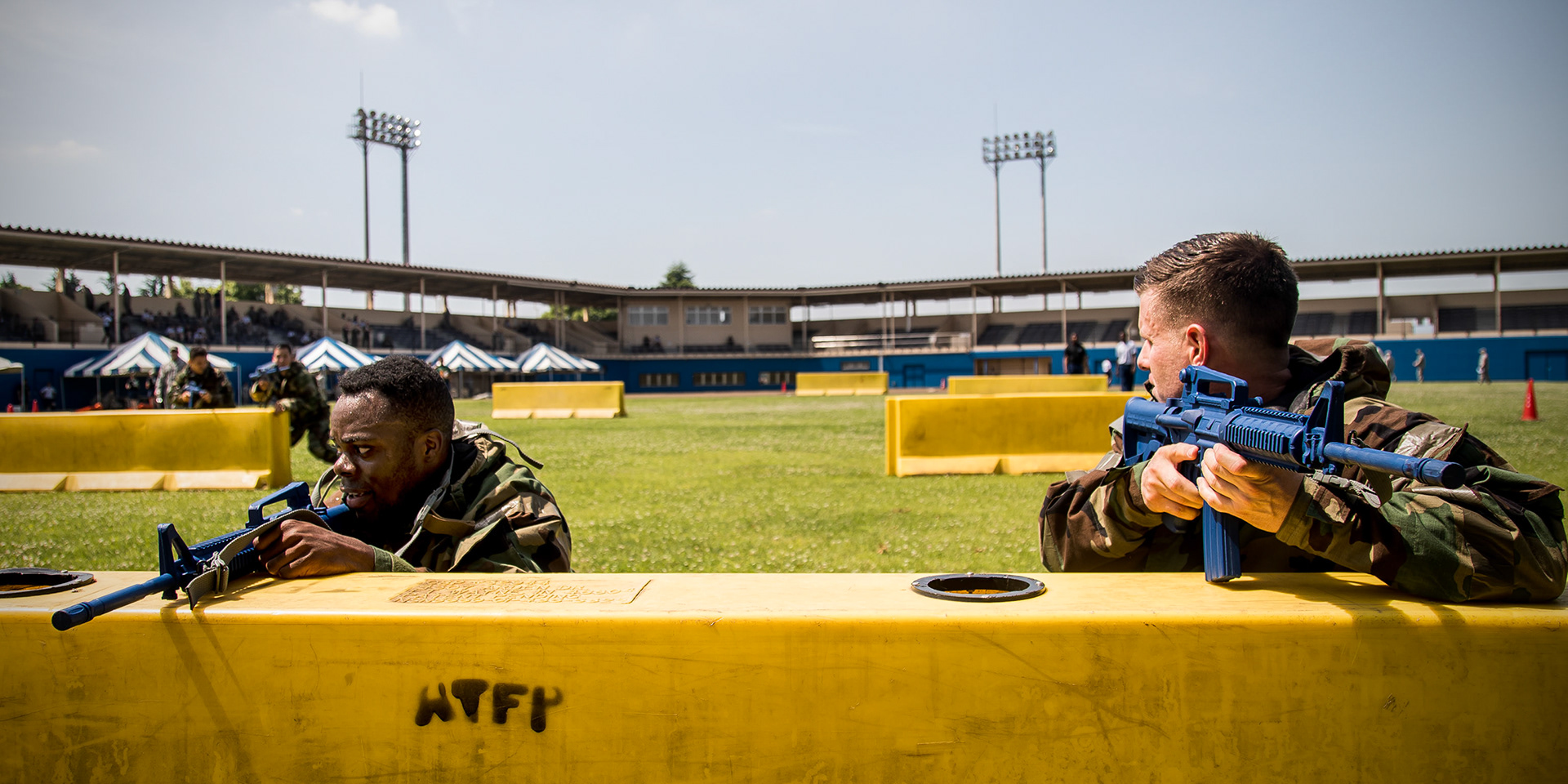 Maj. Logan Smith, 374 th Civil Engineer Squadron operations flight commander, right front, shouts to Airmen to move forwards after providing simulated cover during an Ability to Survive and Operate (ATSO) Rodeo at Yokota Air Base, Japan, June 8, 2018. The rodeo involved participants wearing different stages of mission-oriented protective posture (MOPP) gear after pushing a Humvee and going through various areas of training including self-aid and buddy care, post-attack reconnaissance, four-person relay, and "shoot, move and communicate." (U.S. Air Force photo by Yasuo Osakabe)