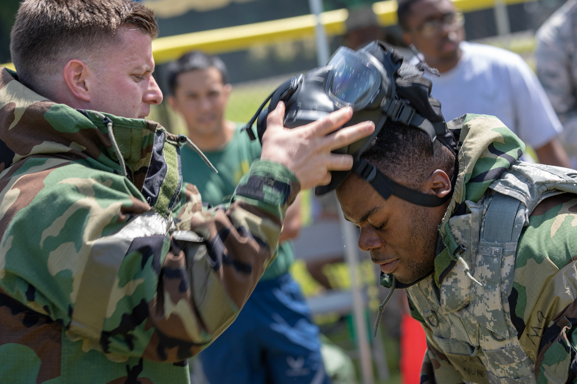Maj. Logan Smith, left, 374th Civil Engineer Squadron operation flight commander, removes Senior Airman Felix Nunez, right, 374th CES electrical system technician, gas mask during an Ability to Survive and Operate (ATSO) Rodeo at Yokota Air Base, Japan, June 8, 2018. The rodeo involved participants wearing different stages of mission-oriented protective posture (MOPP) gear after pushing a Humvee and going through various areas of training including self-aid and buddy care, post-attack reconnaissance, four-person relay, and "shoot, move and communicate." (U.S. Air Force photo by Yasuo Osakabe)
